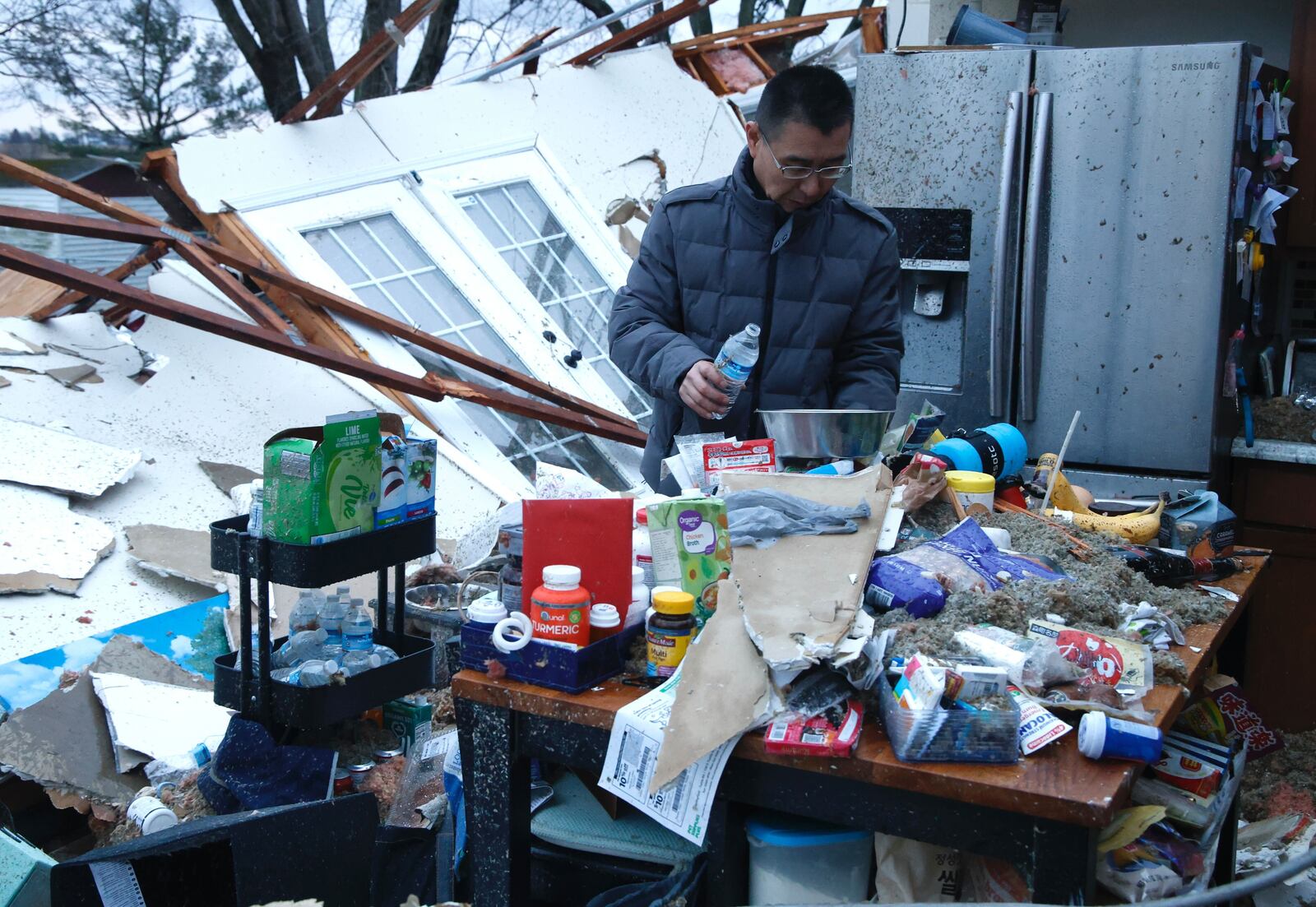 Shoji Uota gets his dog some fresh water in what’s left of his kitchen on Ridge Road Wednesday, Feb. 28, 2024. BILL LACKEY/STAFF