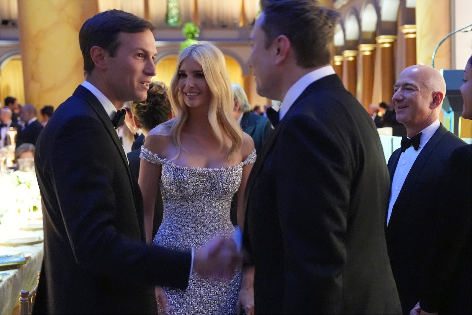 Elon Musk shakes hands with Jared Kushner as Ivanka Trump and Jeff Bezos watch, before President-elect Donald Trump speaks at a dinner at the Building Museum, Sunday, Jan. 19, 2025, in Washington. (AP Photo/Evan Vucci)