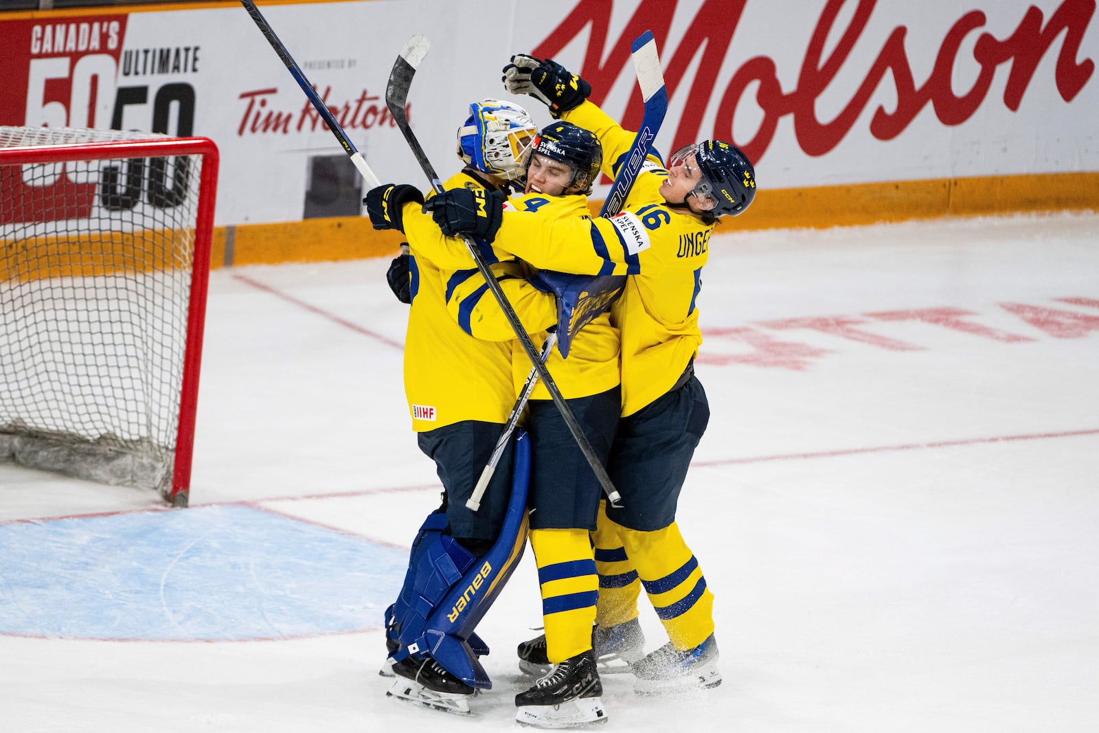 Team Sweden goaltender Melker Thelin (35) celebrates his team's win over Team Latvia with defenseman Axel Sandin-Pellikka (4) and forward Felix Unger Sorum (16) after an IIHF World Junior Hockey Championship quarterfinal match in Ottawa, Ontario Thursday, Jan. 2, 2025. (Spencer Colby/The Canadian Press via AP)