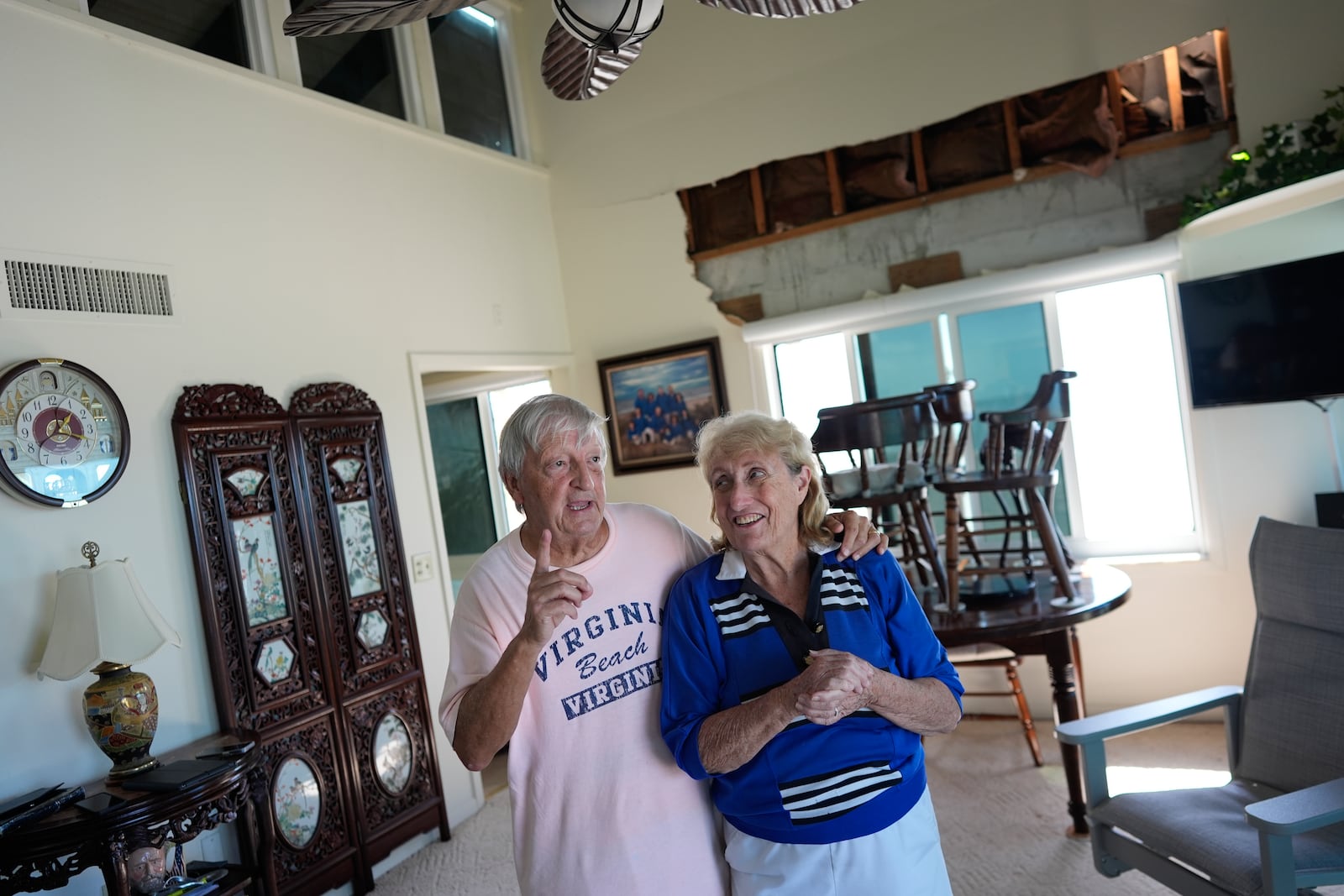 Ron and Jean Dyer, high school sweethearts who have been married for 60 years, talk in the living room of their second-floor beachfront condominium, which lost its roof and a section of wall during Hurricane Milton, in Venice, Fla., Saturday, Oct. 12, 2024. (AP Photo/Rebecca Blackwell)