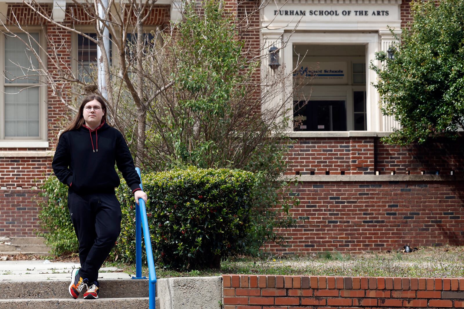 Glenn Thompson, a Durham School of the Arts graduate, poses in front of the school in Durham, N.C., Monday, March 10, 2025. (AP Photo/Karl DeBlaker)