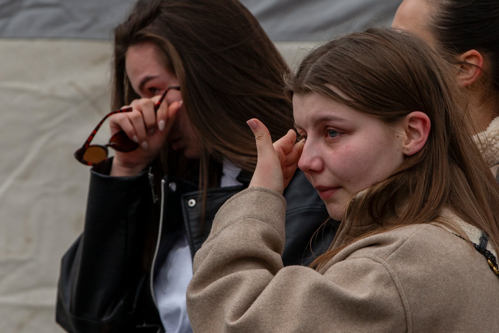 Women cry and wait in line to write condolence messages for the victims of a massive nightclub fire in the town of Kocani, North Macedonia, Monday, March 17, 2025. (AP Photo/Visar Kryeziu)