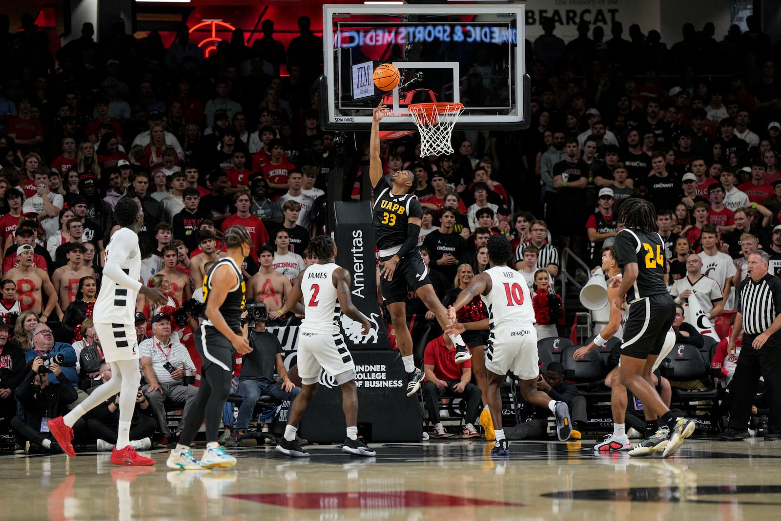 Arkansas-Pine Bluff guard Quentin Bolton (33) shoots against Cincinnati's Jizzle James (2) and Josh Reed (10) during the first half of an NCAA college basketball game, Monday, Nov. 4, 2024, in Cincinnati. (AP Photo/Jeff Dean)