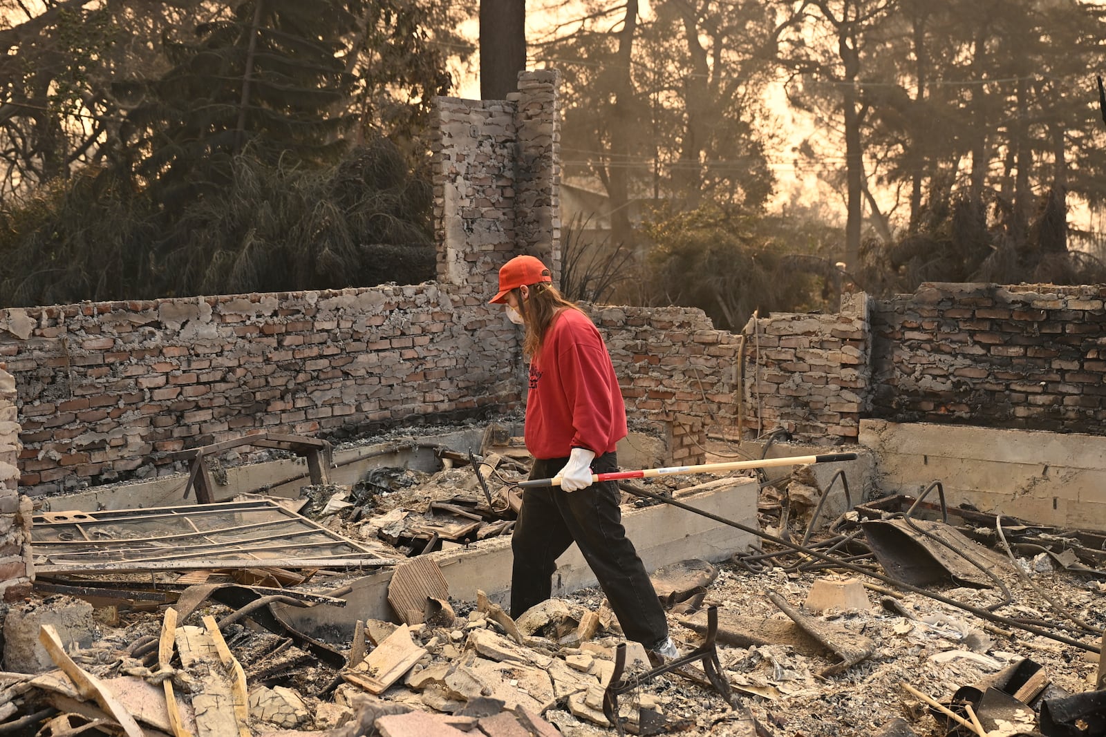 A man searches though his destroyed home after the Eaton Fire in Altadena, Calif., Thursday, Jan. 9, 2025. (AP Photo/Nic Coury)