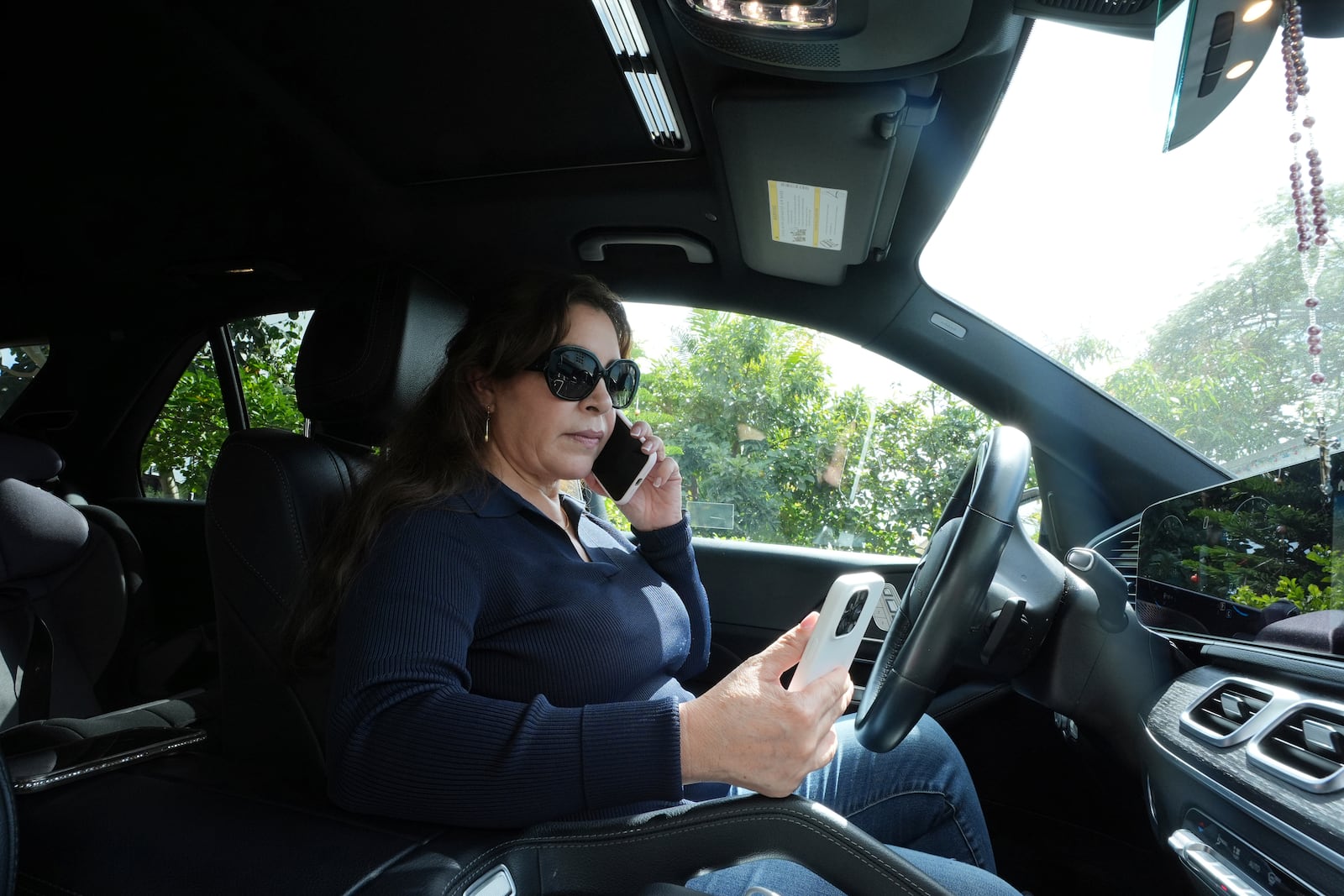 Immigration advocate Nora Sandigo frantically calls immigration attorneys to help a Guatemalan man detained by ICE, Thursday, Feb. 13, 2025, in Homestead. The Guatemalan family has been in the U.S. for many years and has U.S.-born children and grandchildren. (AP Photo/Marta Lavandier)