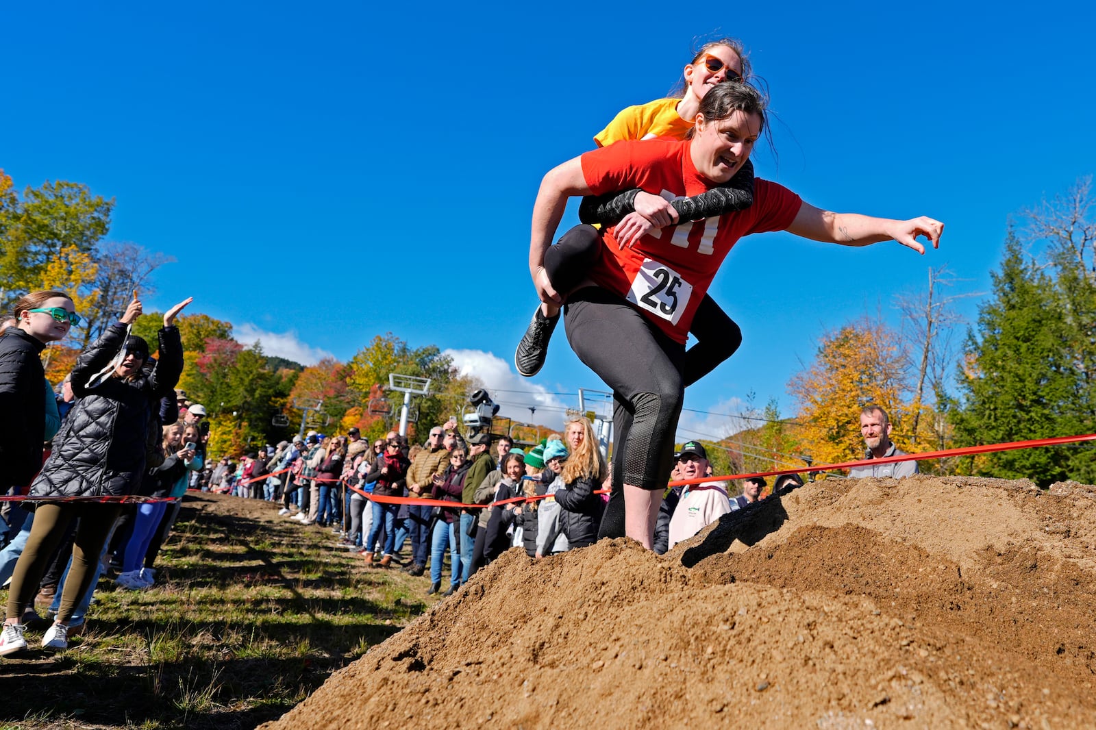 Molly Sunburn carries Megan Crowley over a sand pile during the North American Wife Carrying Championship, Saturday, Oct. 12, 2024, at Sunday River ski resort in Newry, Maine. (AP Photo/Robert F. Bukaty)