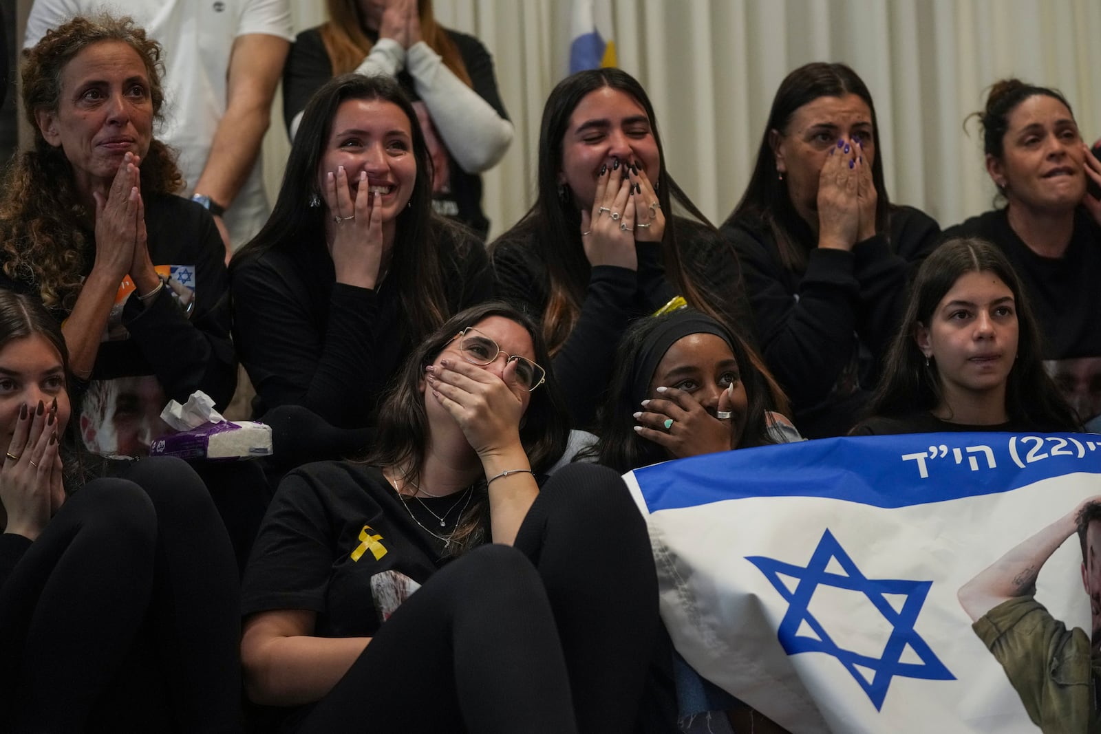 Friends of Sagui Dekel Chen react as they watch a live broadcast of his release from Hamas captivity in Giv'ot Bar, southern Israel, Saturday, Feb. 15, 2025. (AP Photo/Maya Aleruzzo)