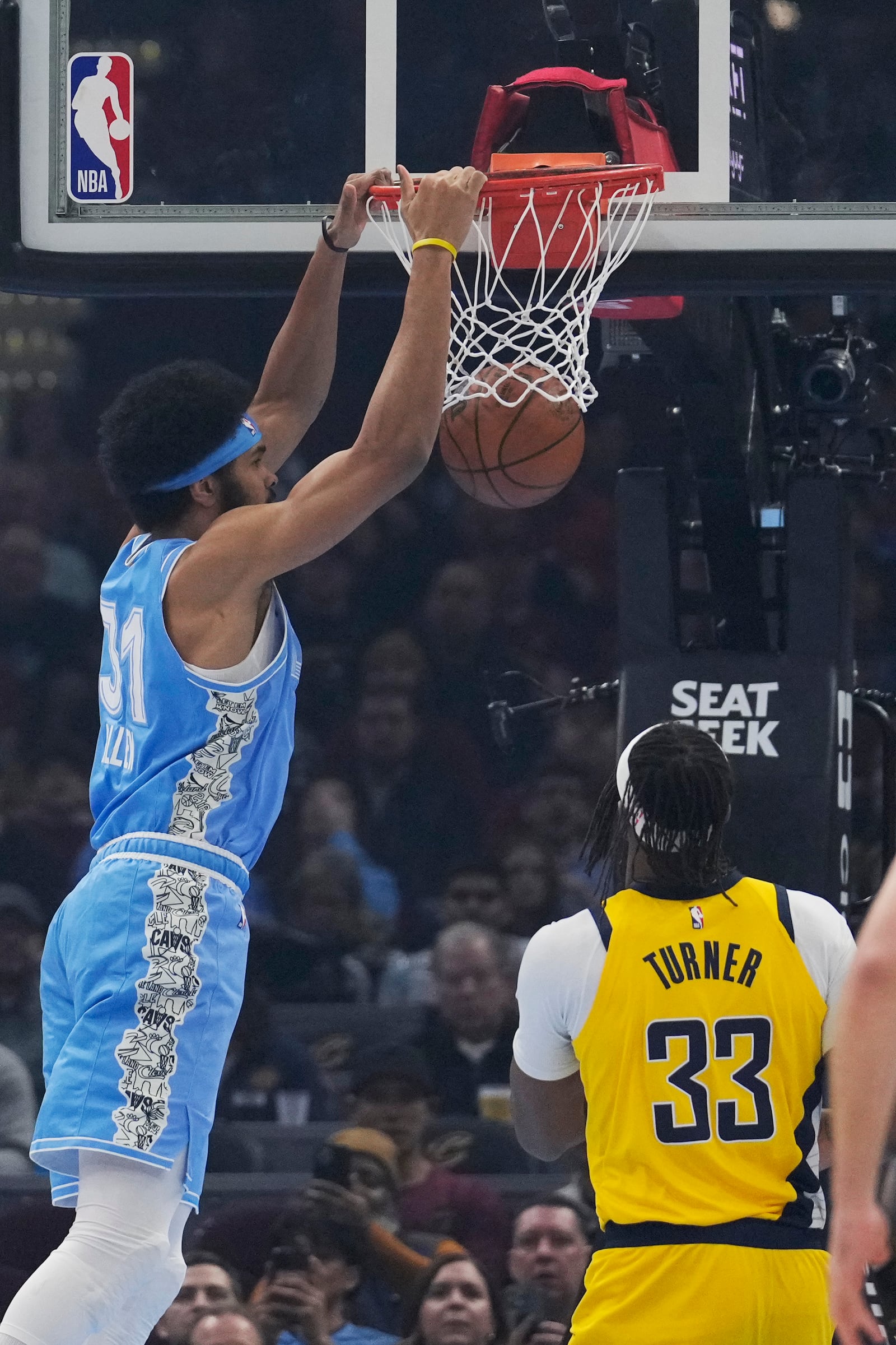 Cleveland Cavaliers center Jarrett Allen, left, dunks on front of Indiana Pacers center Myles Turner (33) in the first half of an NBA basketball game, Sunday, Jan. 12, 2025, in Cleveland. (AP Photo/Sue Ogrocki)