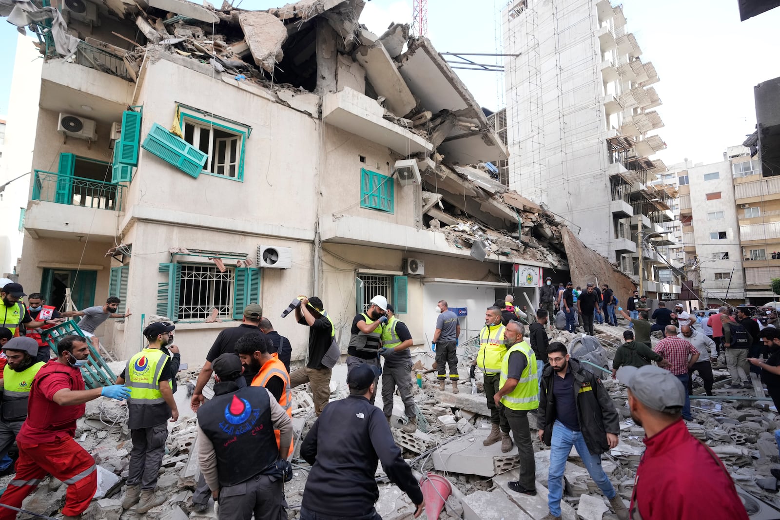 Residents and rescuers gather near a damaged building at the site of an Israeli airstrike in central Beirut's Ras el-Nabaa neighborhood, Lebanon, Sunday, Nov. 17, 2024. (AP Photo/Hassan Ammar)