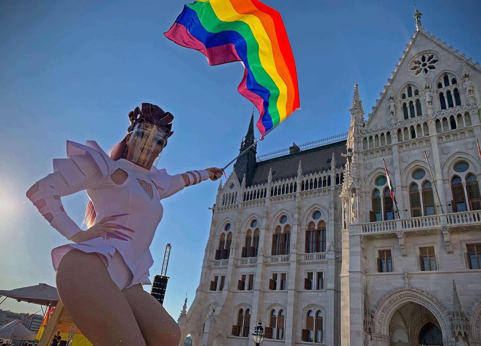 FILE - A participant waves a rainbow flag during an LGBT rights demonstration in front of the Hungarian Parliament building in Budapest, Hungary on June 14, 2021. (AP Photo/Bela Szandelszky, File)