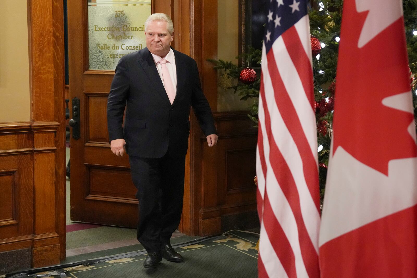 Ontario Premier Doug Ford steps out of an office to speak to the media outside of his office at the Ontario Legislature, in Toronto, on Wednesday, Dec. 11, 2024. (Chris Young/The Canadian Press via AP)