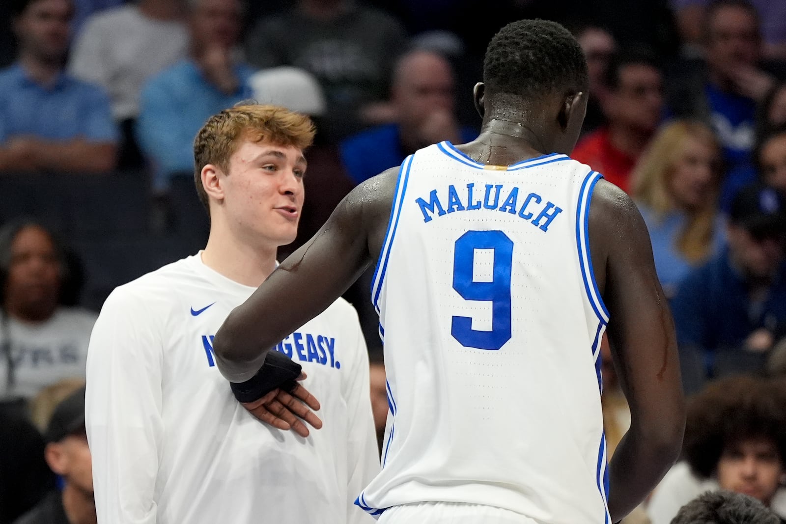 Duke forward Cooper Flagg, left, is greeted by center Khaman Maluach during the second half of an NCAA college basketball game against Georgia Tech in the quarterfinals of the Atlantic Coast Conference tournament, Thursday, March 13, 2025, in Charlotte, N.C. Flagg was injured in the first half. (AP Photo/Chris Carlson)