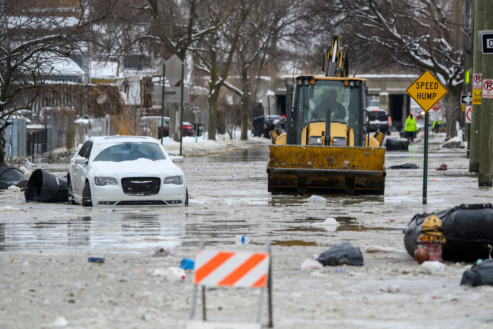 A front end loader pushes down Green Street after a water main break in Detroit caused massive flooding, triggering evacuations, Monday, Feb. 17, 2025. (Andy Morrison/Detroit News via AP)