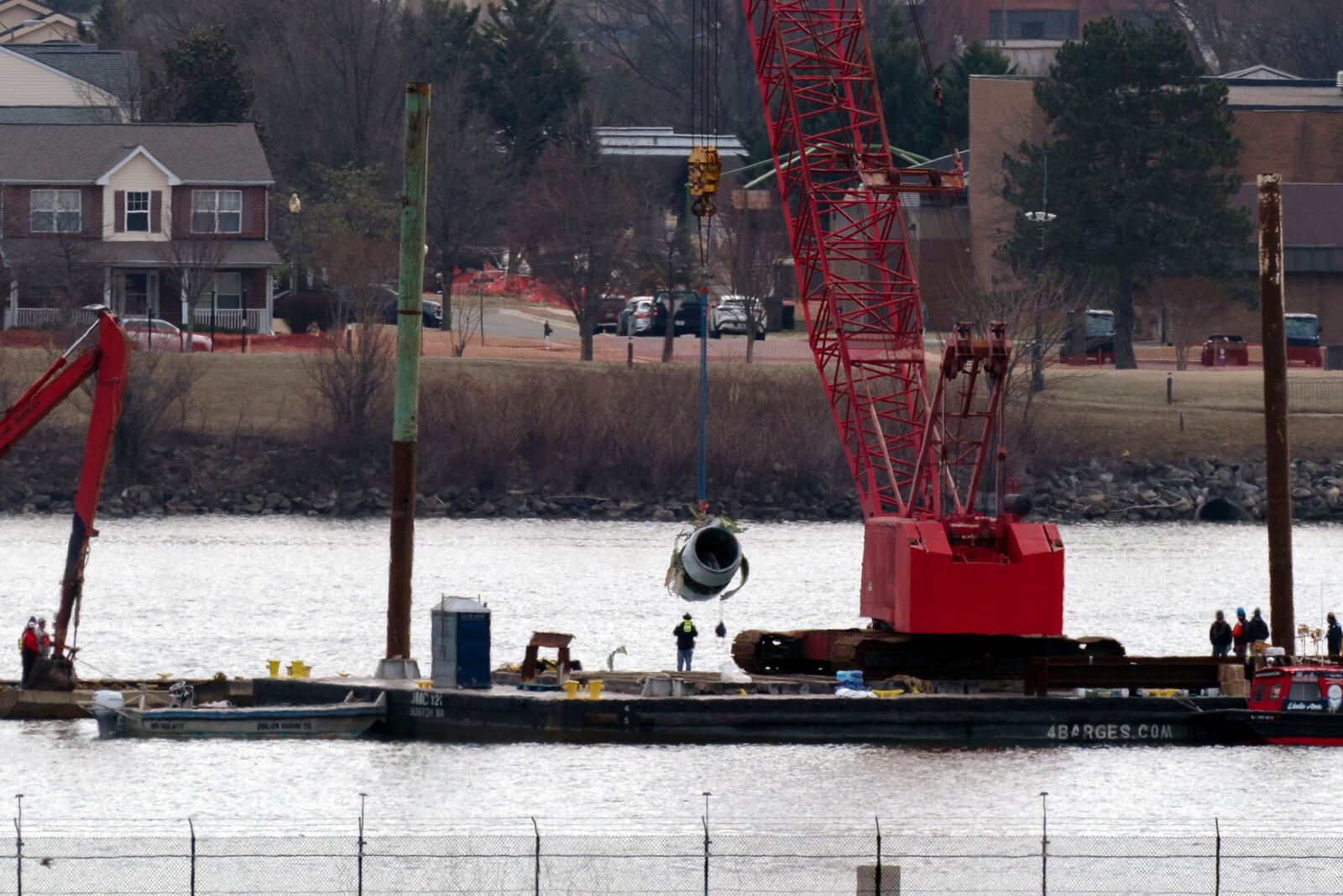 Rescue and salvage crews pull up a plane engine as cranes work near the wreckage of an American Airlines jet in the Potomac river from Ronald Reagan Washington National Airport, Monday, Feb. 3, 2025, in Arlington, Va. (AP Photo/Jose Luis Magana)