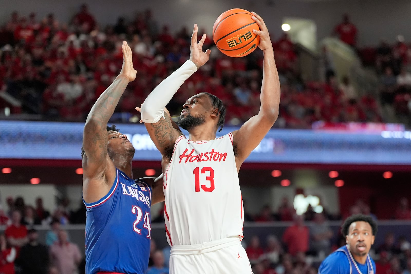 Houston's J'Wan Roberts (13) shoots as Kansas' KJ Adams Jr. (24) defends during the second half of an NCAA college basketball game Monday, March 3, 2025, in Houston. (AP Photo/David J. Phillip)