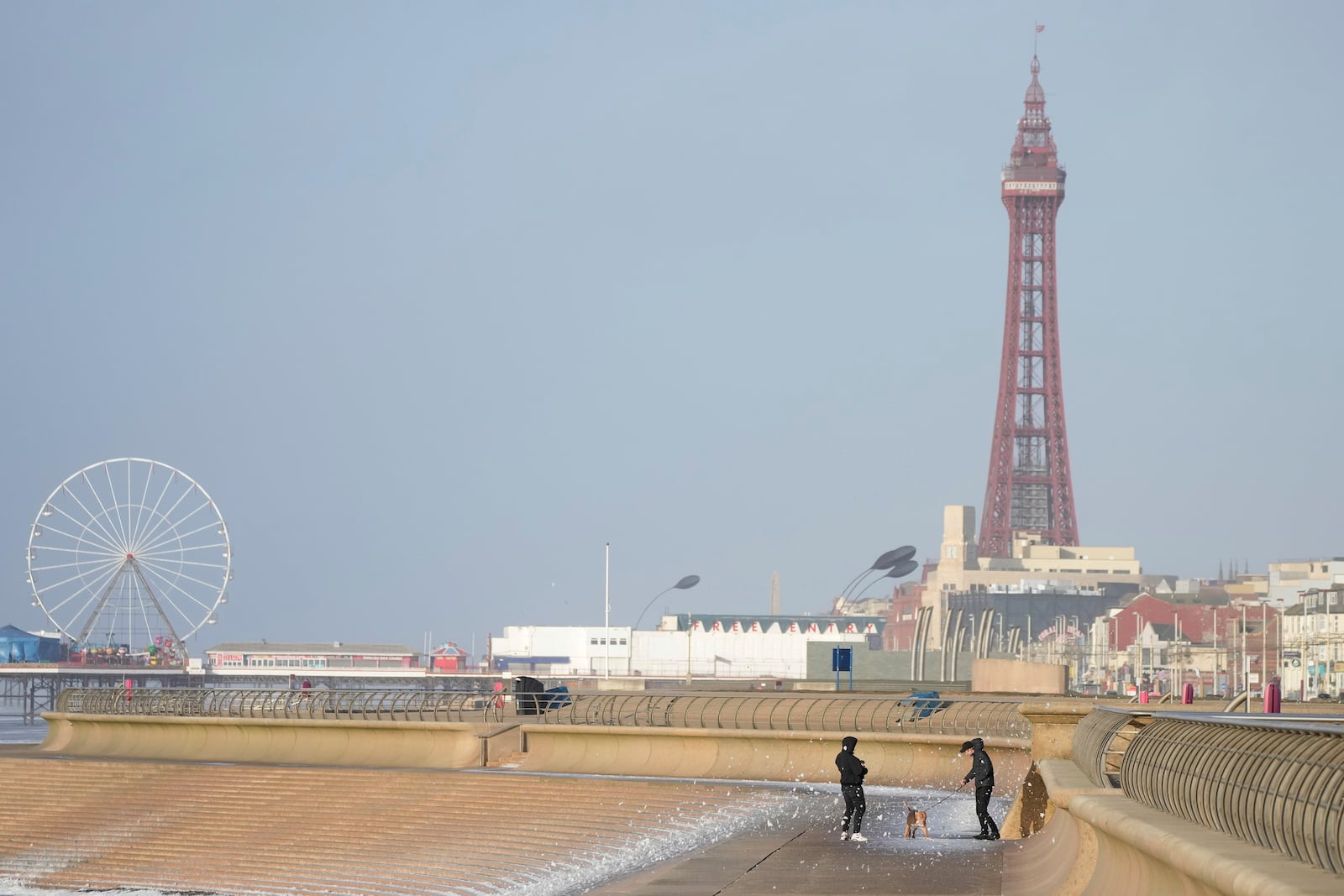 Dog walkers brave the wind as Storm Eowyn hits the country in Blackpool, England, Friday, Jan. 24, 2025.(AP Photo/Jon Super)