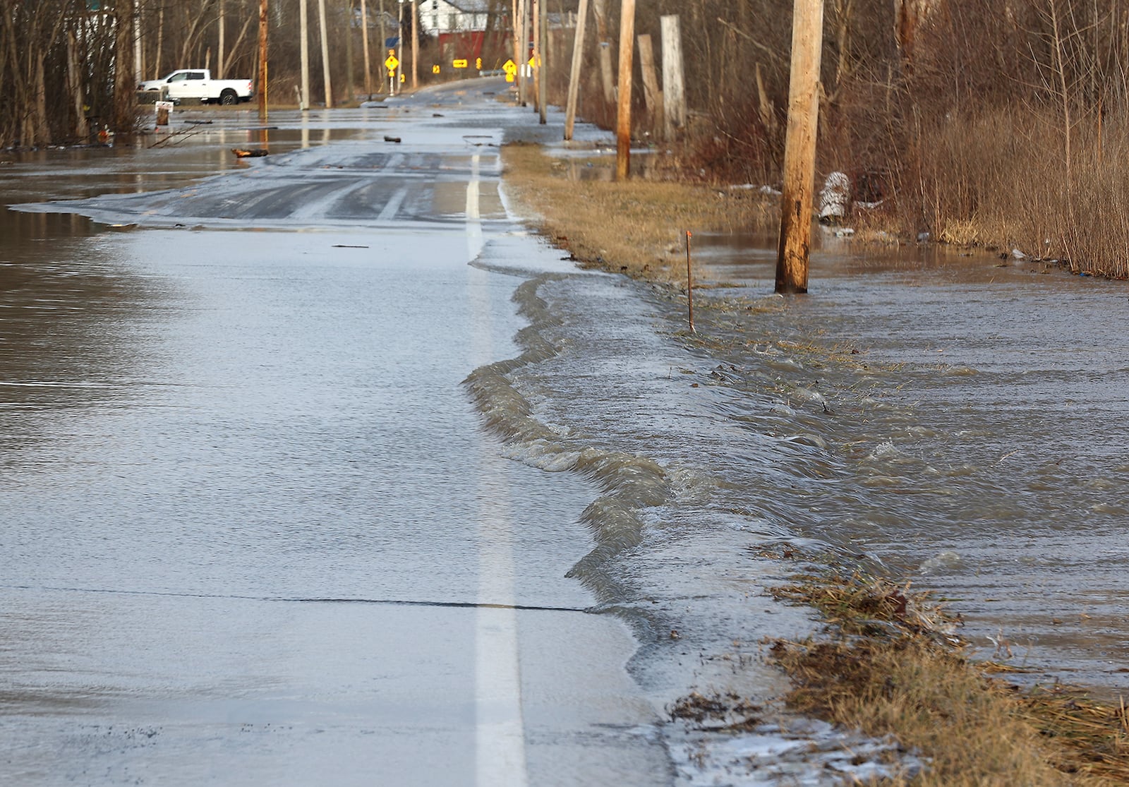 Water flows across Spangler Road in Clark County in this February 2022 file photo. The Clark County Engineer's Office is planning upgrades to deal with flooding and safety on the Bethel Twp. road. BILL LACKEY/STAFF