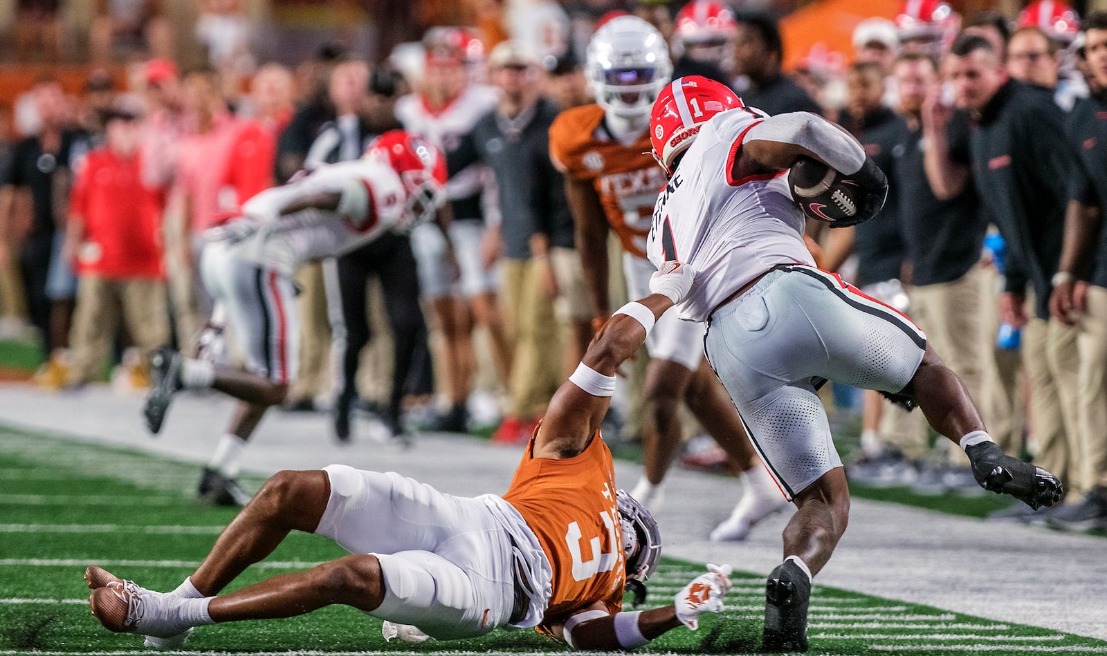 Georgia running back Trevor Etienne (1) is dragged down by Texas defensive back Jaylon Guilbeau (3) during the first half of an NCAA college football game in Austin, Texas, Saturday, Oct. 19, 2024. (AP Photo/Rodolfo Gonzalez)