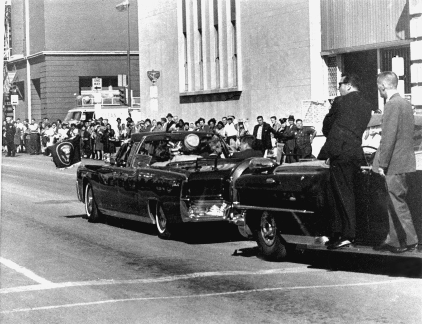 FILE - Secret servicemen standing on running boards follow the presidential limousine carrying President John F. Kennedy, right, rear seat, and first lady Jacqueline Kennedy, left, as well as Texas Gov. John Connally and his wife, Nellie, in Dallas, Texas, Nov. 22, 1963. (AP Photo/Jim Altgens, File)