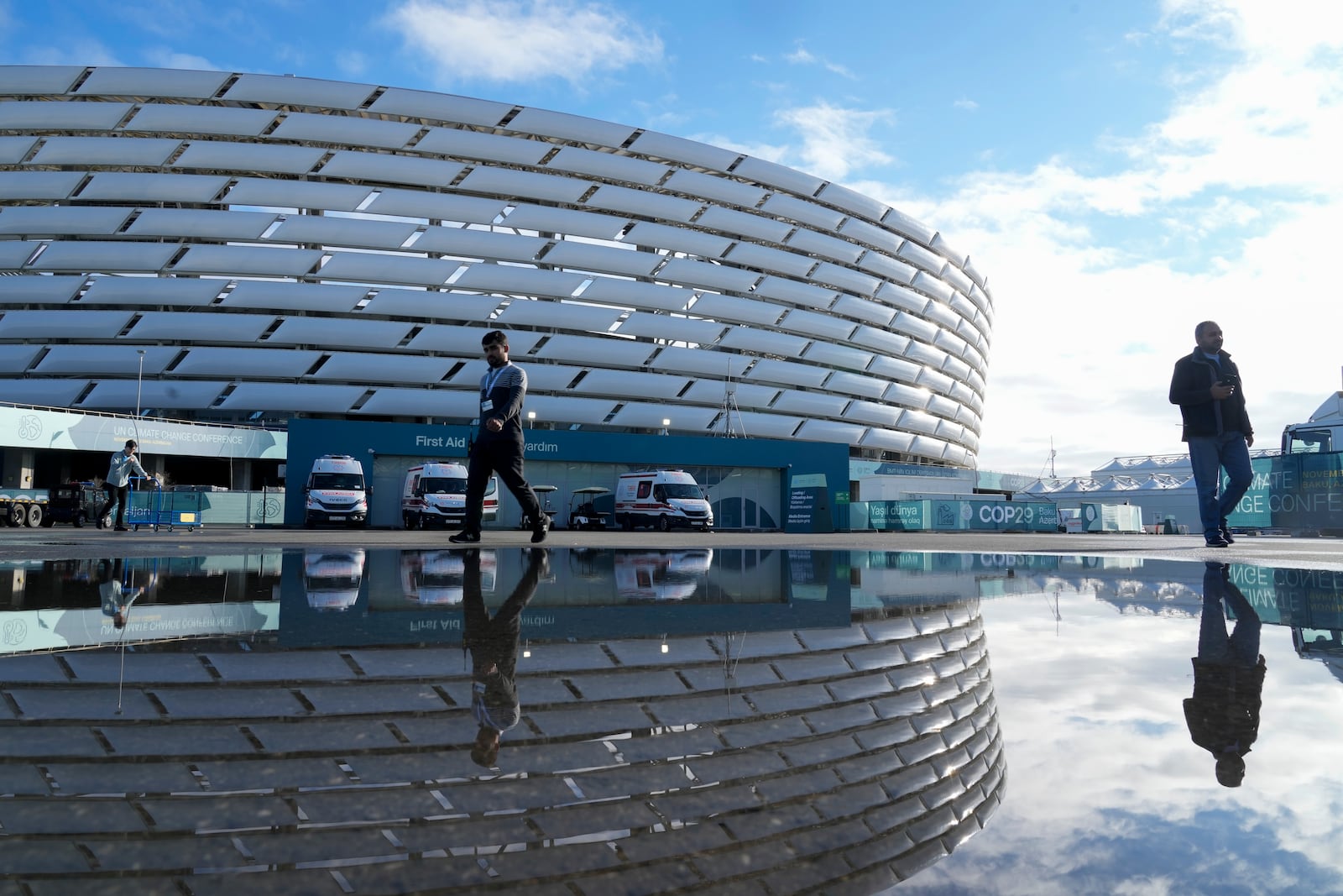 People walk outside the Baku Olympic Stadium at the COP29 U.N. Climate Summit, Thursday, Nov. 14, 2024, in Baku, Azerbaijan. (AP Photo/Rafiq Maqbool)