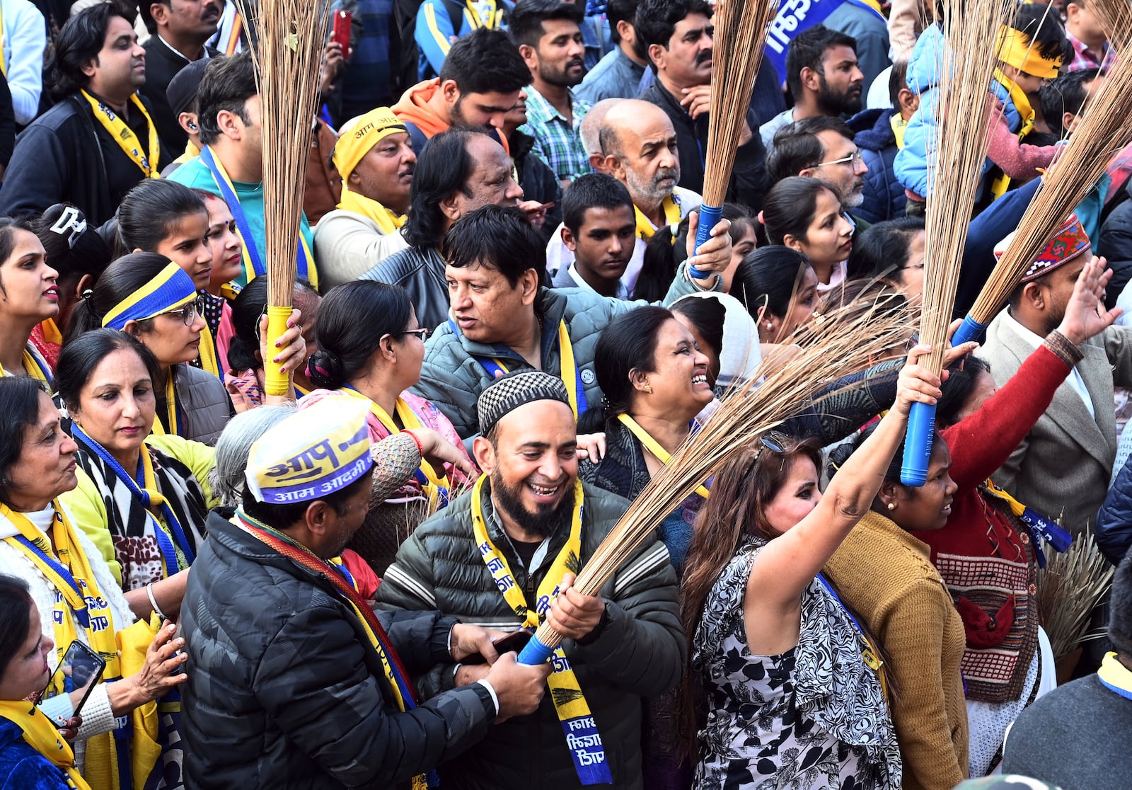 Supporters of Aam Aadmi Party (AAP) carry brooms, their party's symbol, during a show of their party's national convener Arvind Kejriwal as they campaign for Delhi state election, in New Delhi, India, Monday, Feb. 3, 2025. (AP Photo)