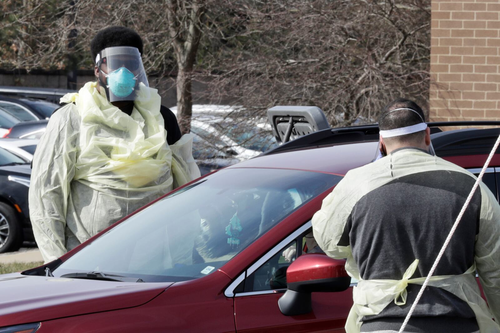 Caregivers talk with a patient at a coronavirus testing center outside at University Hospitals, Monday, March 16, 2020, in Mayfield Heights, Ohio. This site has a capability to test 300 people today. (AP Photo/Tony Dejak)