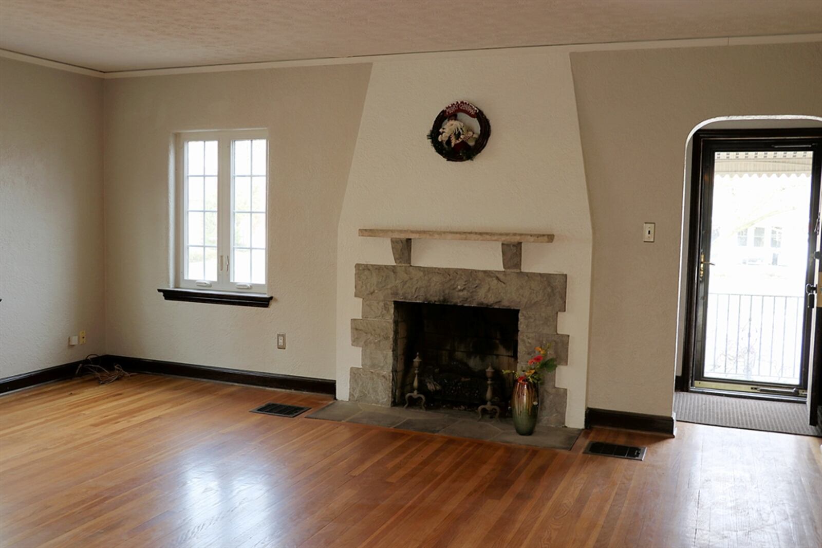 Hardwood flooring fills the entry and continues into the living room. The oak hardwood flooring has been refinished within the living room. A decorative fireplace has a beautiful stone-and-brick surround with stone mantel.