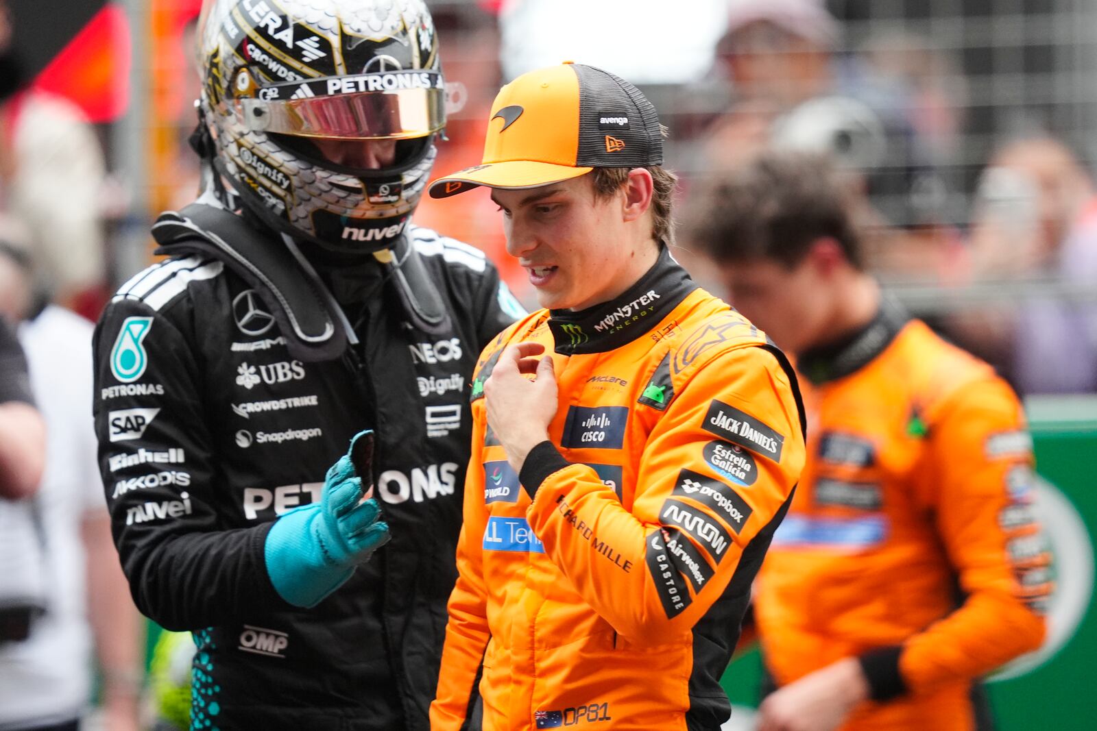 McLaren driver Oscar Piastri of Australia, centre, is congratulated by Mercedes driver George Russell of Britain after winning the Chinese Formula One Grand Prix race at the Shanghai International Circuit, Shanghai, Sunday, March 23, 2025. (AP Photo)