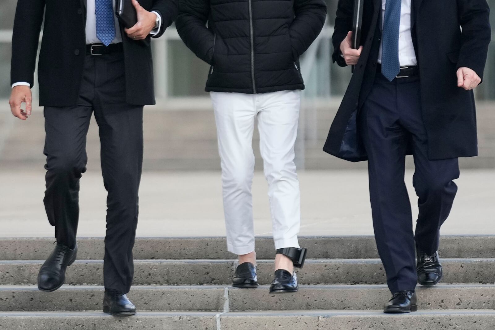 Matthew Smith, center, wearing an ankle monitor, leaves a federal courthouse in Central Islip, N.Y., Tuesday, Dec. 3, 2024. (AP Photo/Seth Wenig)