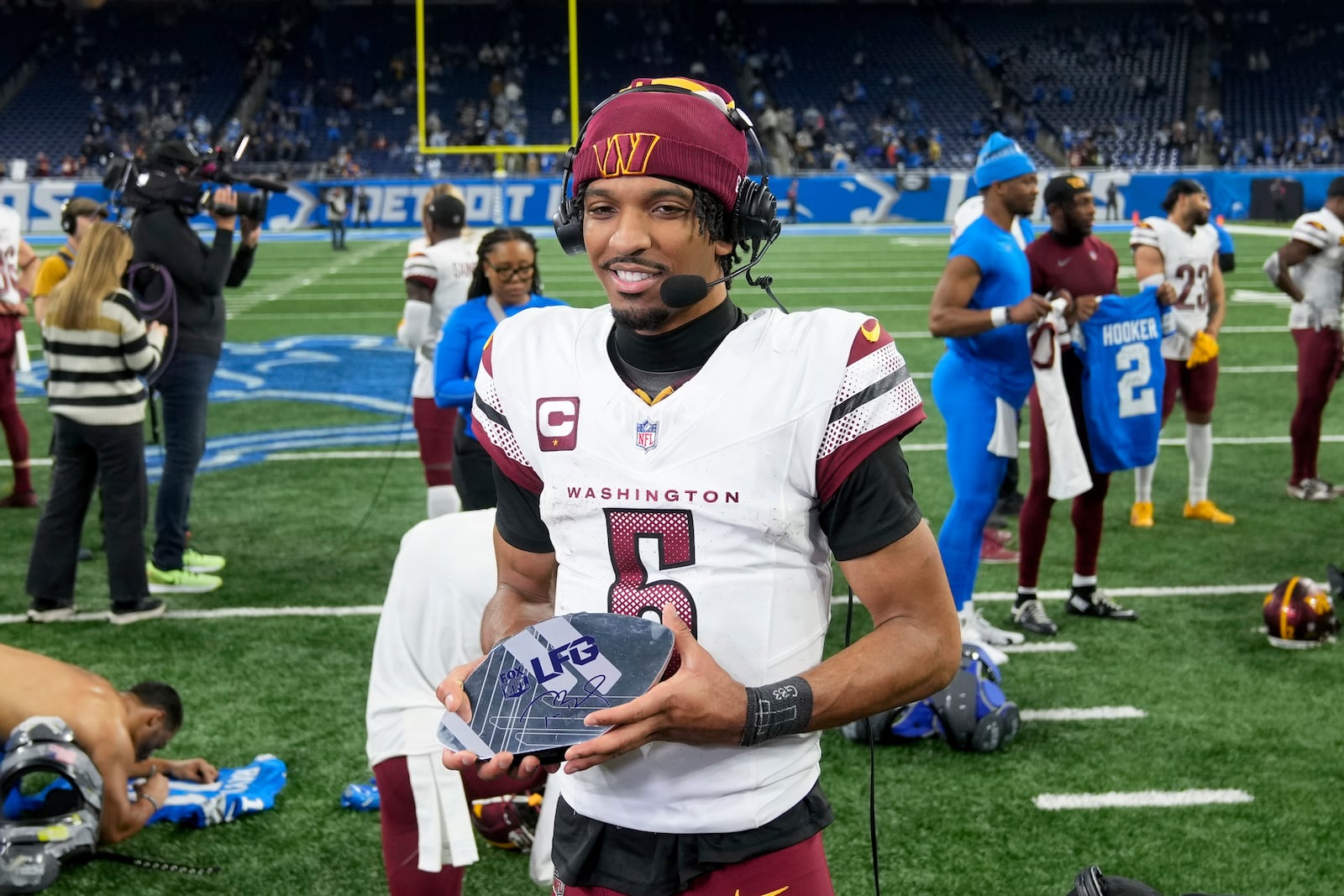 Washington Commanders quarterback Jayden Daniels (5) does an interview after an NFL football divisional playoff game against the Detroit Lions, Saturday, Jan. 18, 2025, in Detroit. (AP Photo/Seth Wenig)