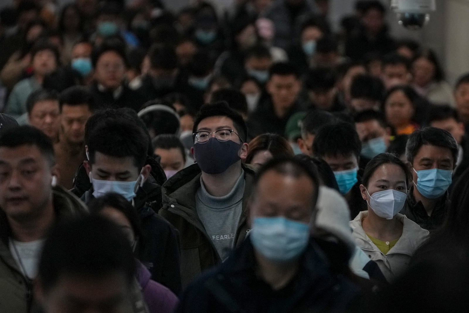 Commuters walk at a walkway of an interchange subway station as they head to work during the morning rush hour in Beijing, Thursday, March 6, 2025. (AP Photo/Andy Wong)