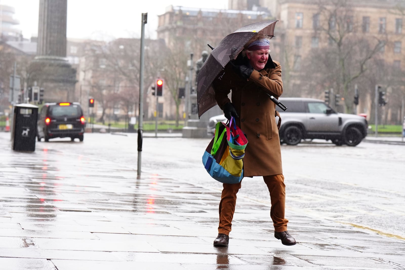 A person battles with an umbrella in the wind during Storm Eowyn on George Street, Edinburgh, Friday Jan. 24, 2025, as Storm Eowyn hits the country. (Jane Barlow/PA via AP)