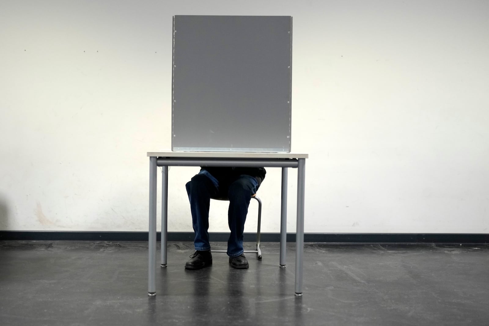 Resident prepares to cast a vote at a polling station in Berlin, Germany, Sunday, Feb. 23, 2025, during the German national election. (AP Photo/Markus Schreiber)