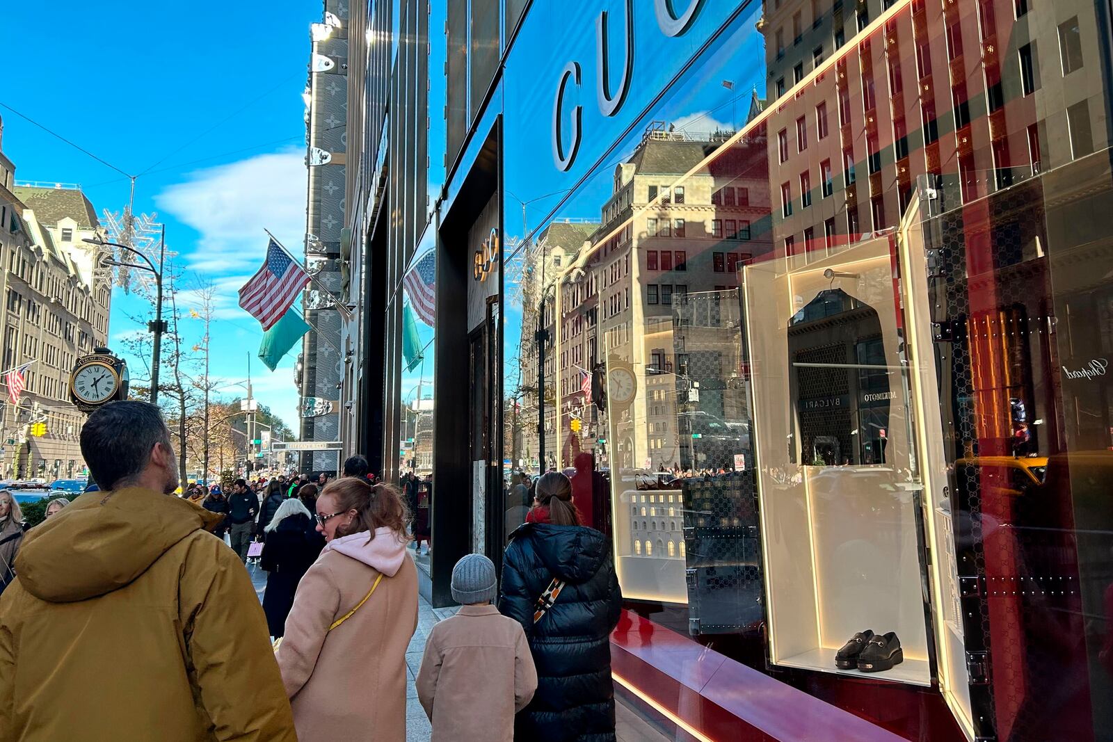 People walk past stores on Fifth Ave. on Sunday, Nov. 24, 2024, in New York. (AP Photo/Anne D'Innocenzio)