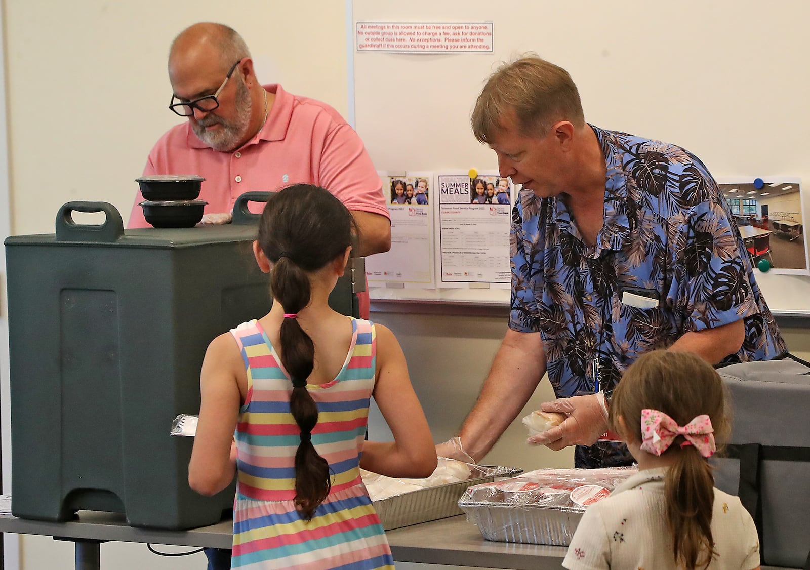 Bill Martino and Don Rumpff, from the Clark County Library, pass out food during the Summer Food Program at the Clark County Library Tuesday, June 14, 2022. BILL LACKEY/STAFF