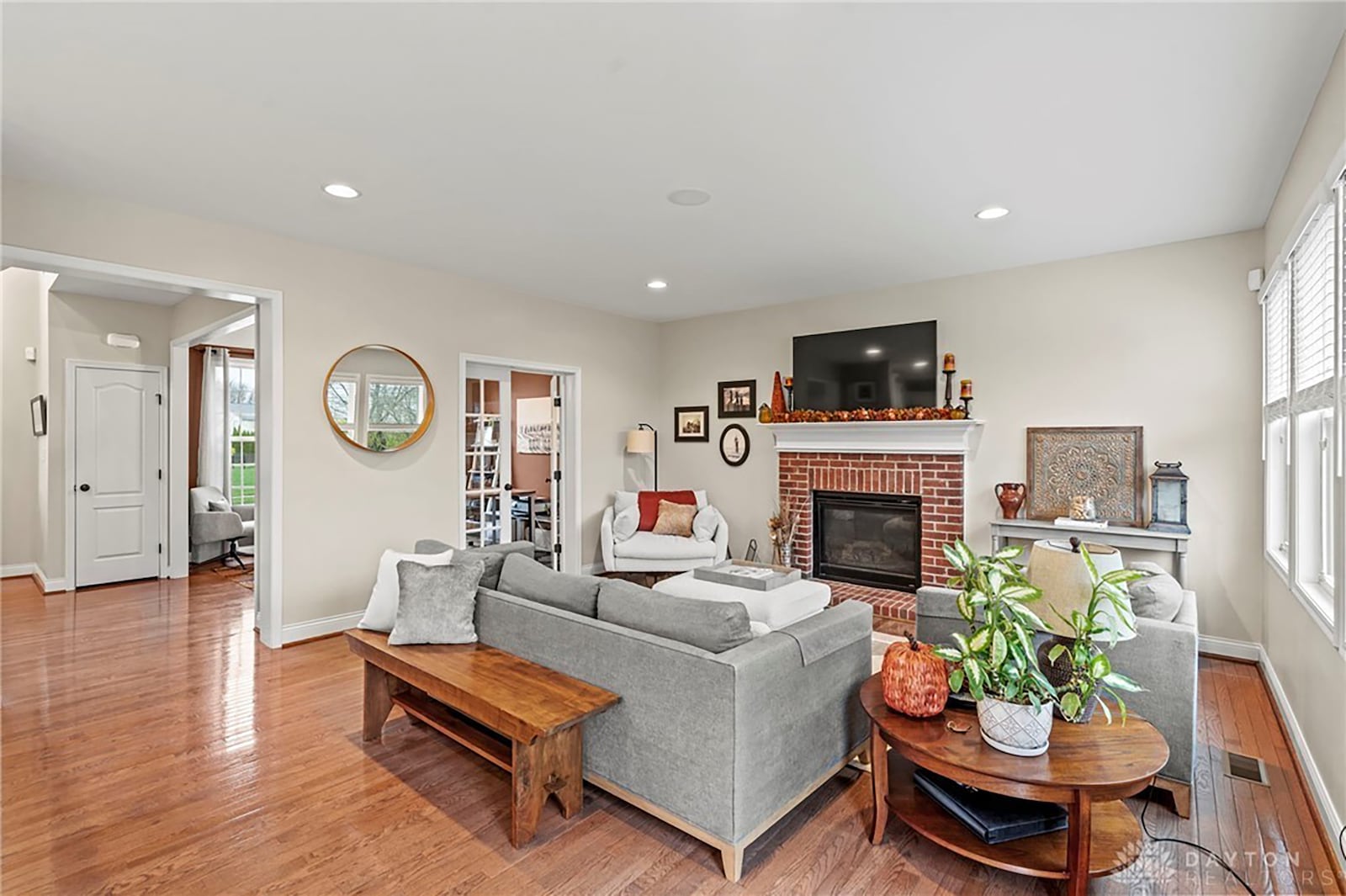 The living room has a gas fireplace, hardwood flooring and a door walking out to the elevated deck.