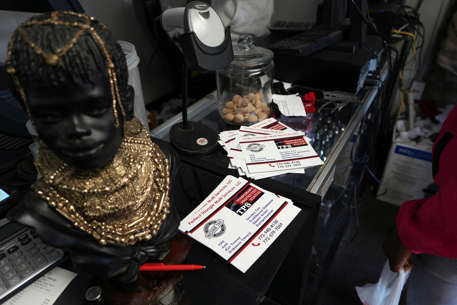 Cards with information on the Temporary Protected Status, which allows thousands of Haitian immigrants to reside legally in the United States, sit on display at Milokan Botanica, a religious supply shop that sells Haitian spiritual and natural healing products, in Springfield, Ohio, Saturday, January 25, 2025. (AP Photo/Luis Andres Henao)