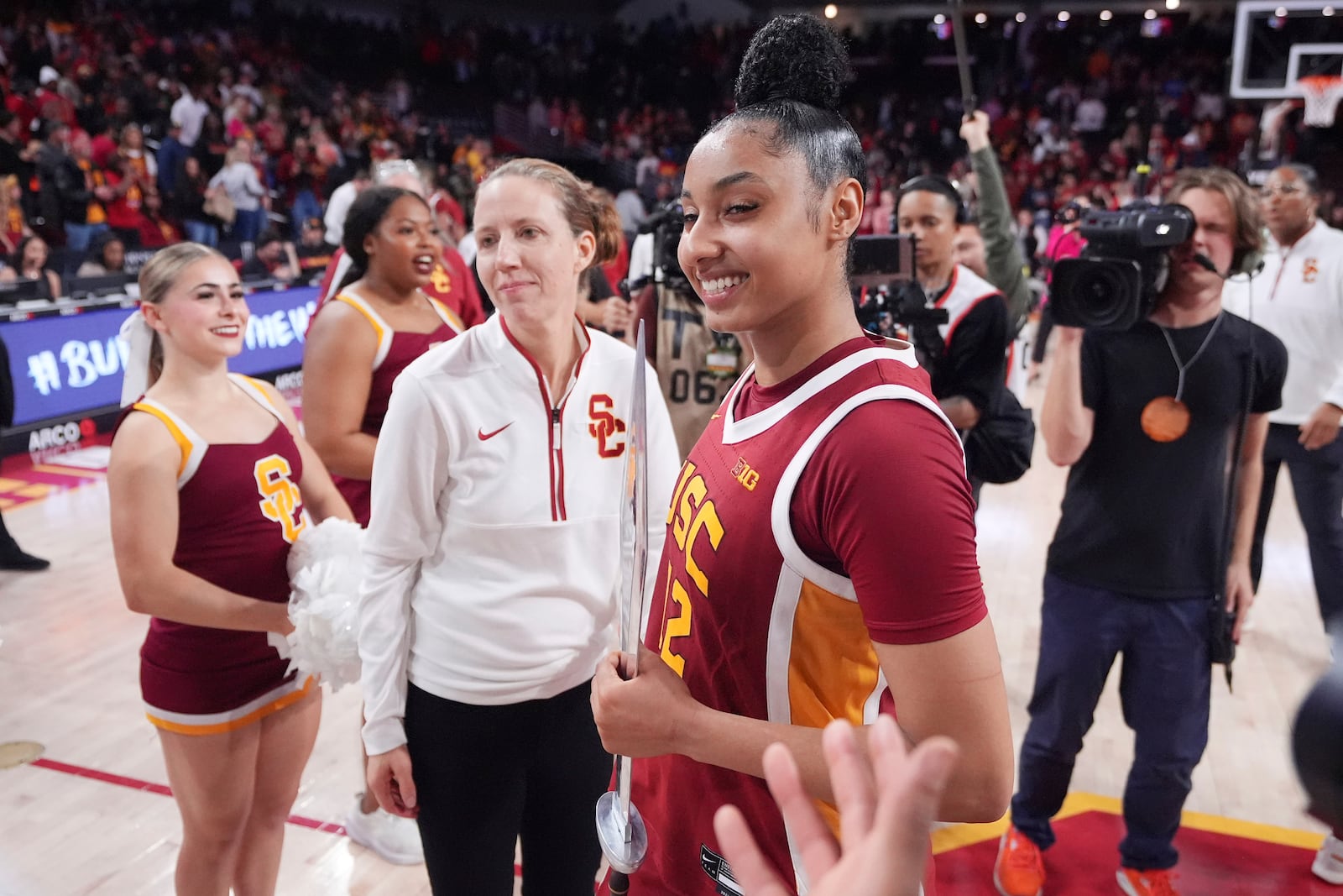 Southern California guard JuJu Watkins, right, smiles as she holds a sword as head coach Lindsay Gottlieb stand by after USC defeated UCLA in an NCAA college basketball game, Thursday, Feb. 13, 2025, in Los Angeles. (AP Photo/Mark J. Terrill)