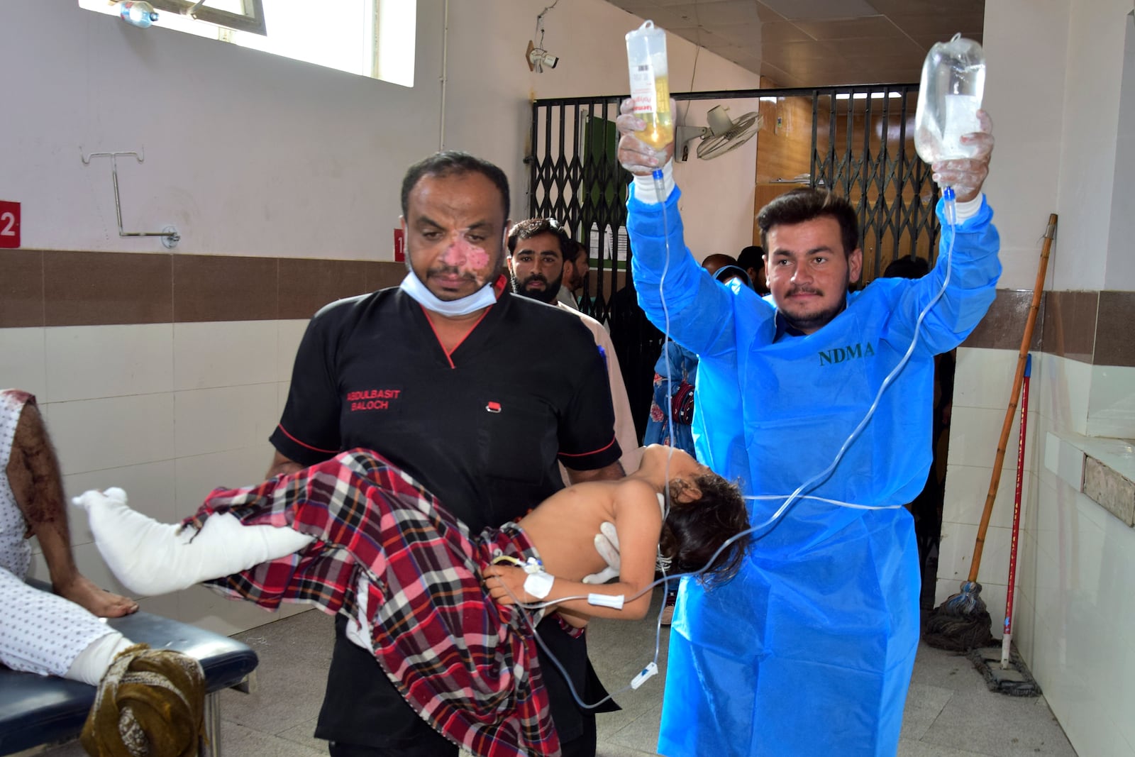 Paramedics carry a girl, who was injured in the bomb explosion in Mastung town, for treatment at a hospital in Quetta, Pakistan, Friday, Nov. 1, 2024. (AP Photo/Arshad Butt)