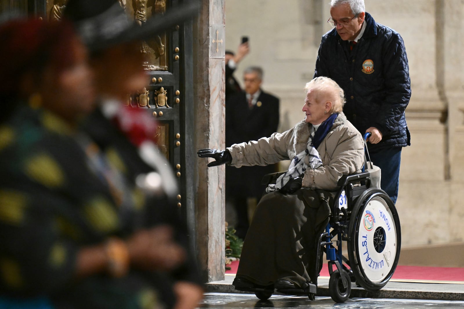 The first pilgrims pass through after Pope Francis opened the Holy Door to mark the opening of the 2025 Catholic Holy Year, or Jubilee, in St. Peter's Basilica, at the Vatican, Tuesday Dec. 24, 2024. (Alberto Pizzoli/Pool via AP)