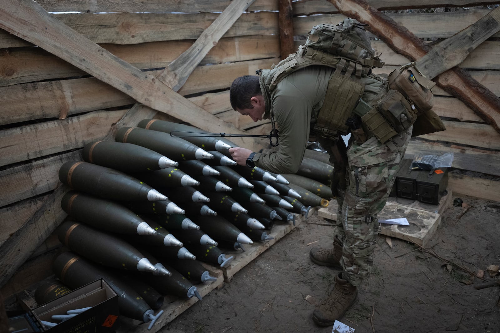 A Ukrainian officer of the 92nd separate assault brigade inspects ammunition in a shelter on the frontline near Vovchansk, Kharkiv region, Ukraine, Monday, Oct. 28, 2024. (AP Photo/Efrem Lukatsky)