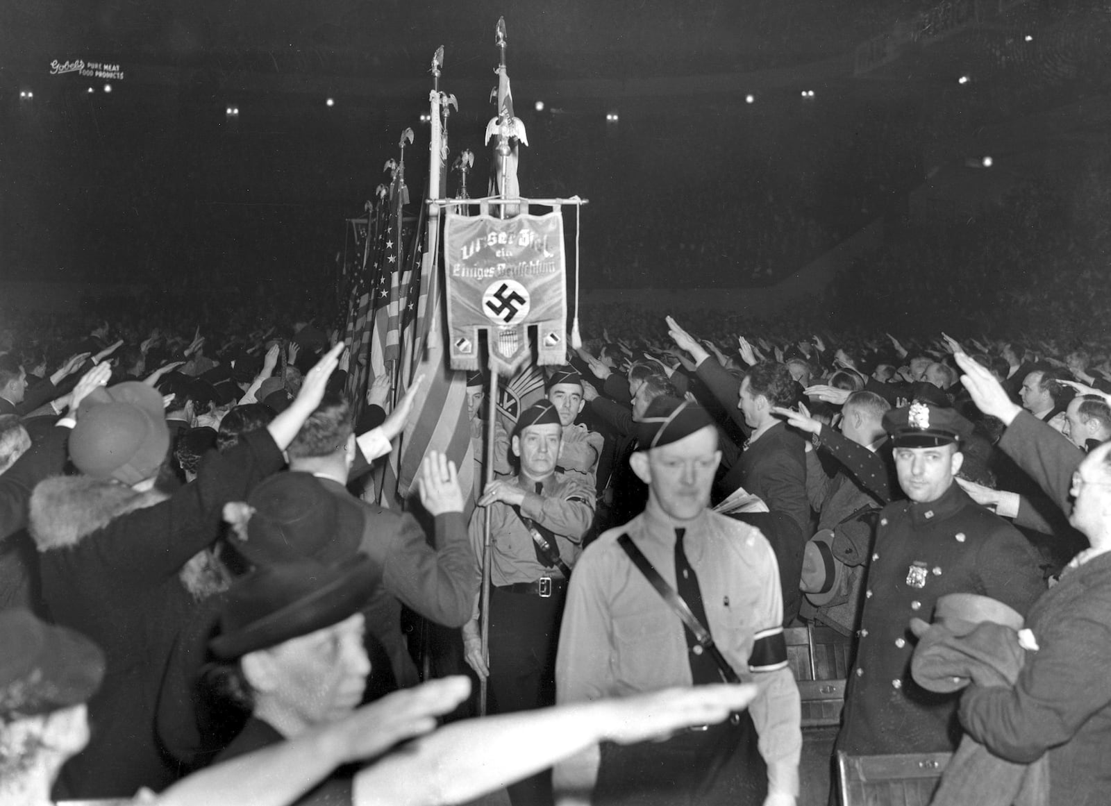 FILE - The crowd responds with a Hitler salute as uniformed members of a German-American Bund color guard march at a gathering in New York's Madison Square Garden, Feb. 20, 1939. (AP Photo/File)