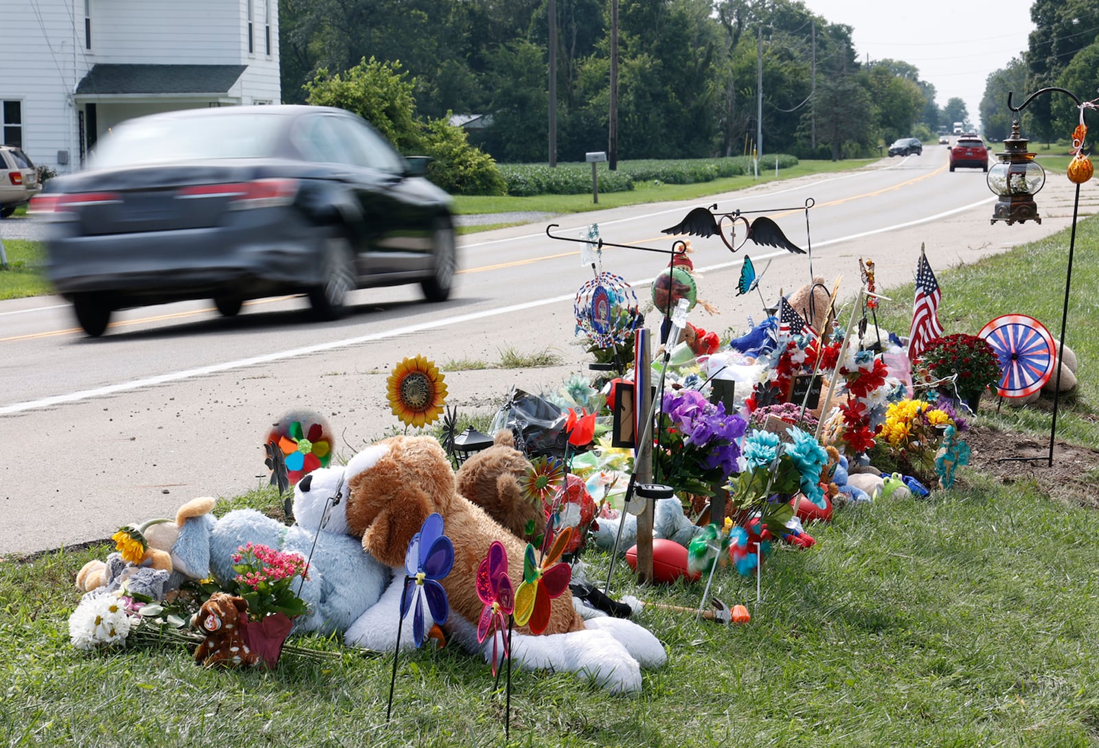 Memorial items and toys are stacked along Troy Road Thursday, August 24, 2023 at the site of Tuesday fatal bus crash. BILL LACKEY/STAFF