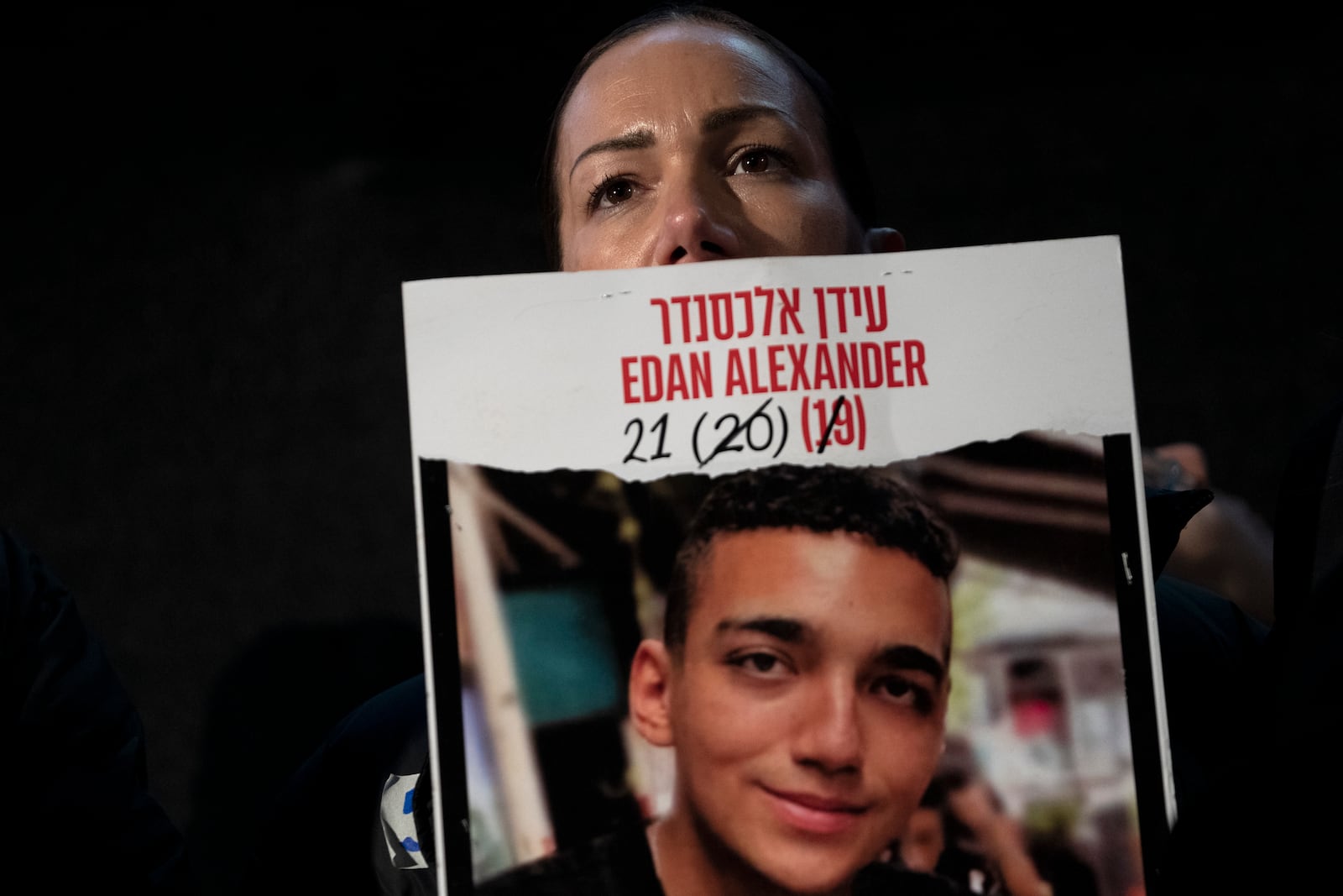 Yael Alexander holds a poster of her son, Edan, who was taken hostage by Hamas militants on Oct. 7, 2023, during a weekly rally for families of hostages held in the Gaza Strip and their supporters, in Tel Aviv, Israel, Saturday, Feb. 22, 2025. (AP Photo/Maya Alleruzzo)