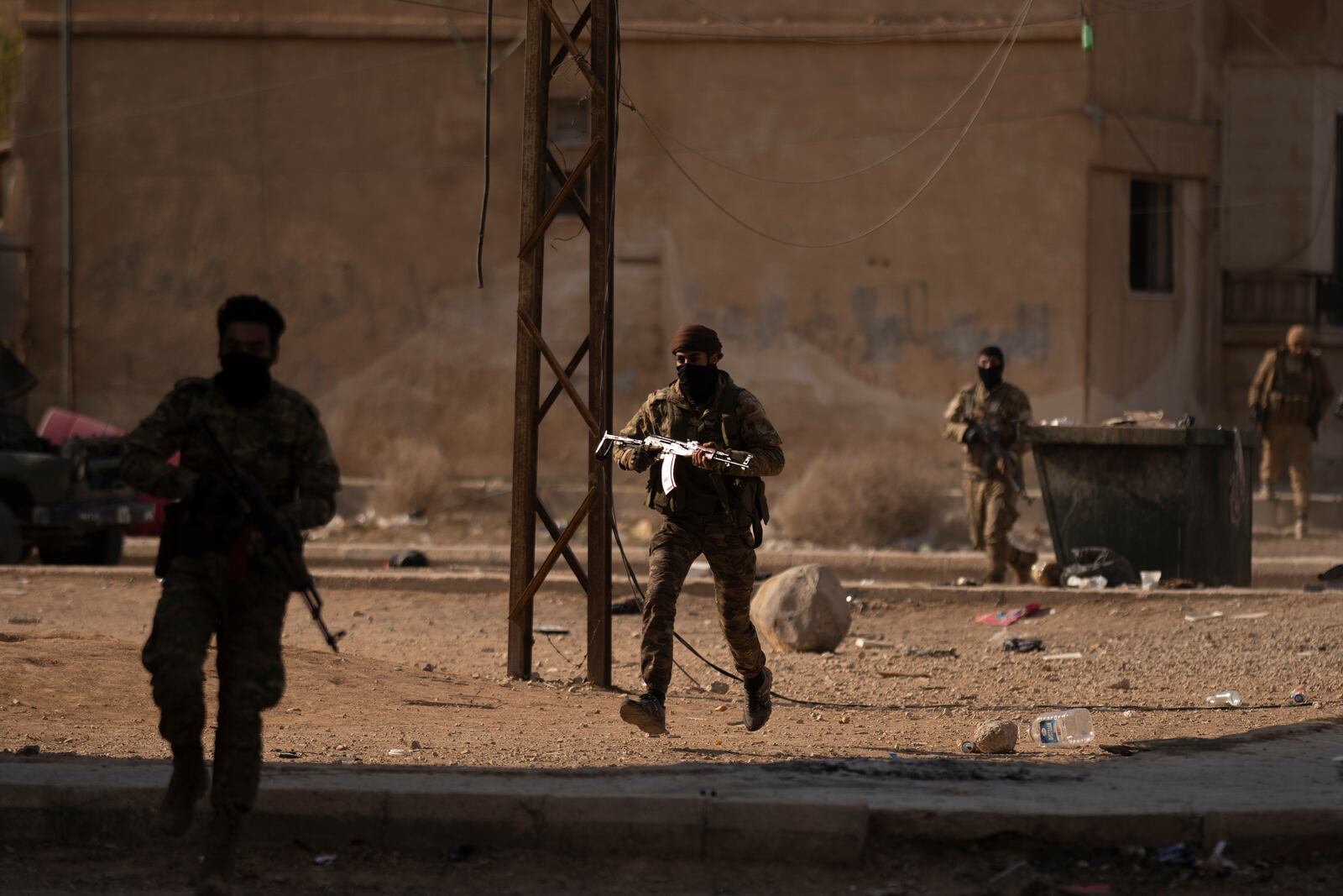 Syrian fighters take position as suspected looters stay inside a building at a residential complex of former Bashar Assad's military officers at the village of Husseiniyeh, in the outskirts of Damascus, Syria, Sunday, Dec. 15, 2024. (AP Photo/Leo Correa)