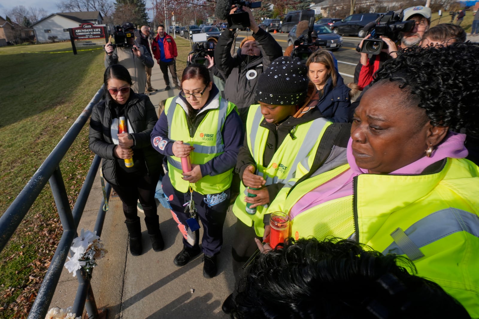 A group says a prayer outside the Abundant Life Christian School Tuesday, Dec. 17, 2024 in Madison, Wis., following a shooting on Monday. (AP Photo/Morry Gash)