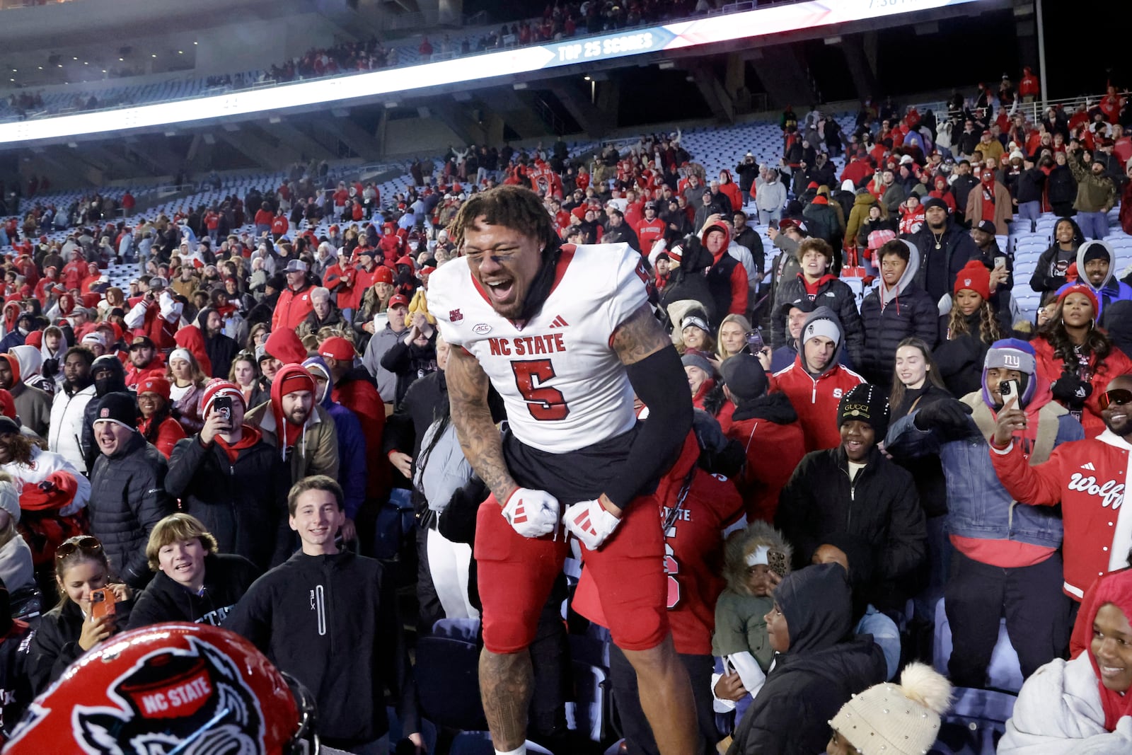 North Carolina State safety DK Kaufman (5) celebrates with the fans after defeating rival North Carolina in an NCAA college football game Saturday, Nov. 30, 2024, in Chapel Hill, N.C. (AP Photo/Chris Seward)