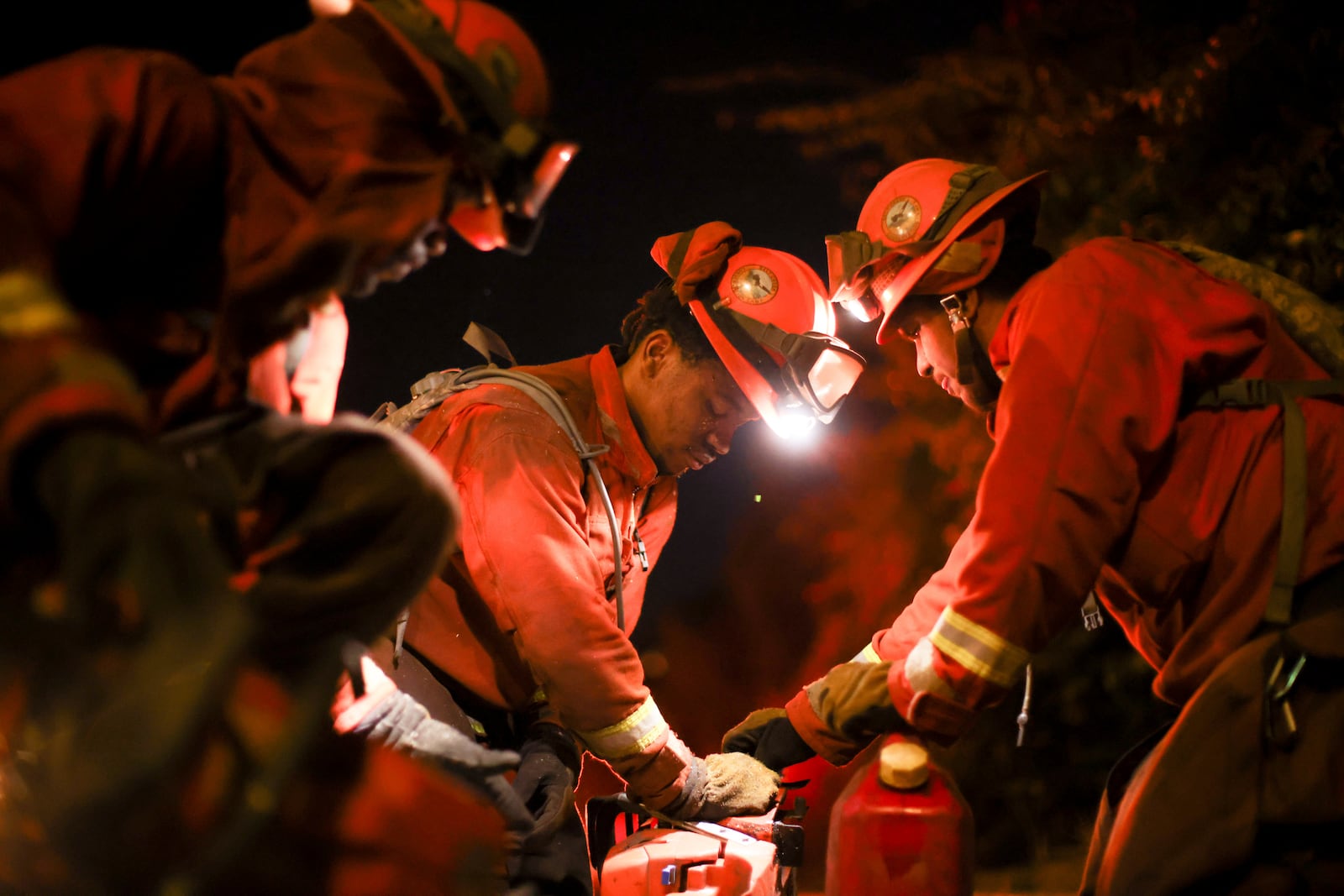 FILE - A California Department of Corrections hand crew works containment lines ahead of the Palisades Fire, Jan. 14, 2025, in Santa Monica, Calif. (AP Photo/Ethan Swope, File)