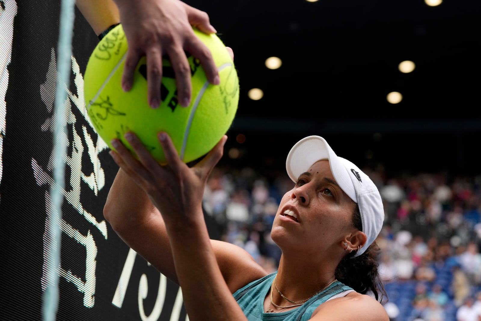 Madison Keys of the U.S. signs autographs after defeating Elina Svitolina of Ukraine in their quarterfinal match at the Australian Open tennis championship in Melbourne, Australia, Wednesday, Jan. 22, 2025. (AP Photo/Manish Swarup)