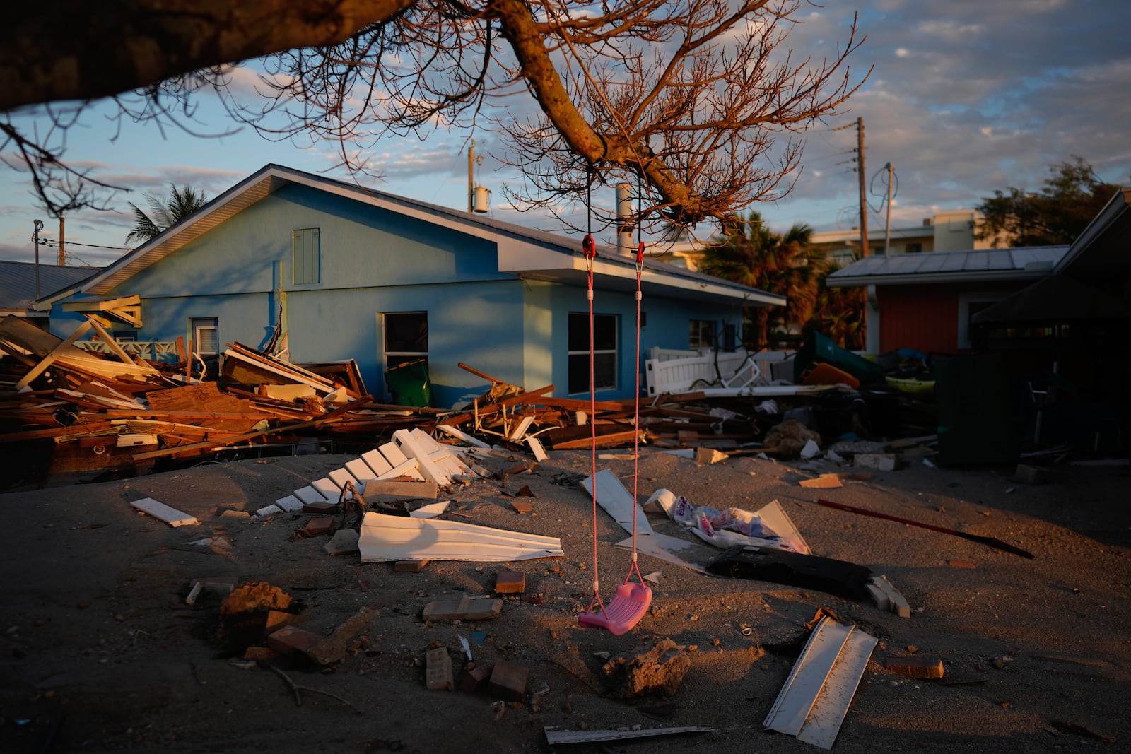 A child's swing still hangs on a tree, surrounded by debris from homes destroyed by Hurricane Milton, on Manasota Key, Fla., Saturday, Oct. 12, 2024. (AP Photo/Rebecca Blackwell)